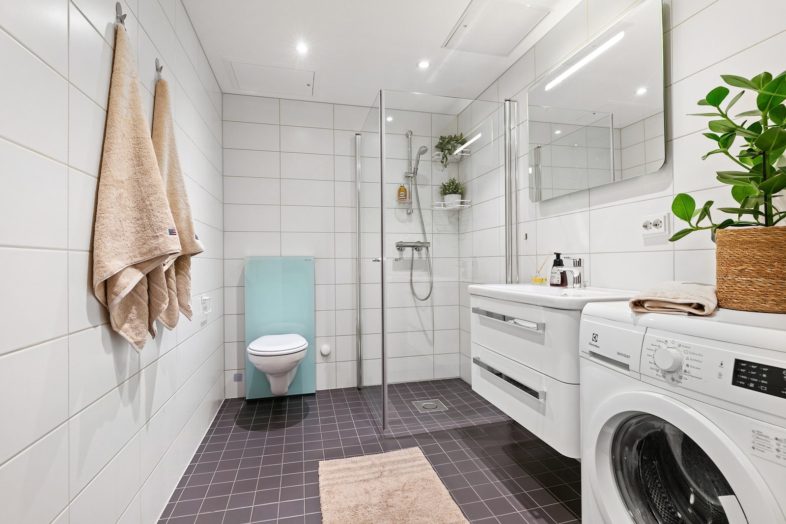 Leiligheten har et flislagt prefabrikkert kabinbad utstyrt med varmekabler og opplegg for oppvaskmaskin. Galleribilde