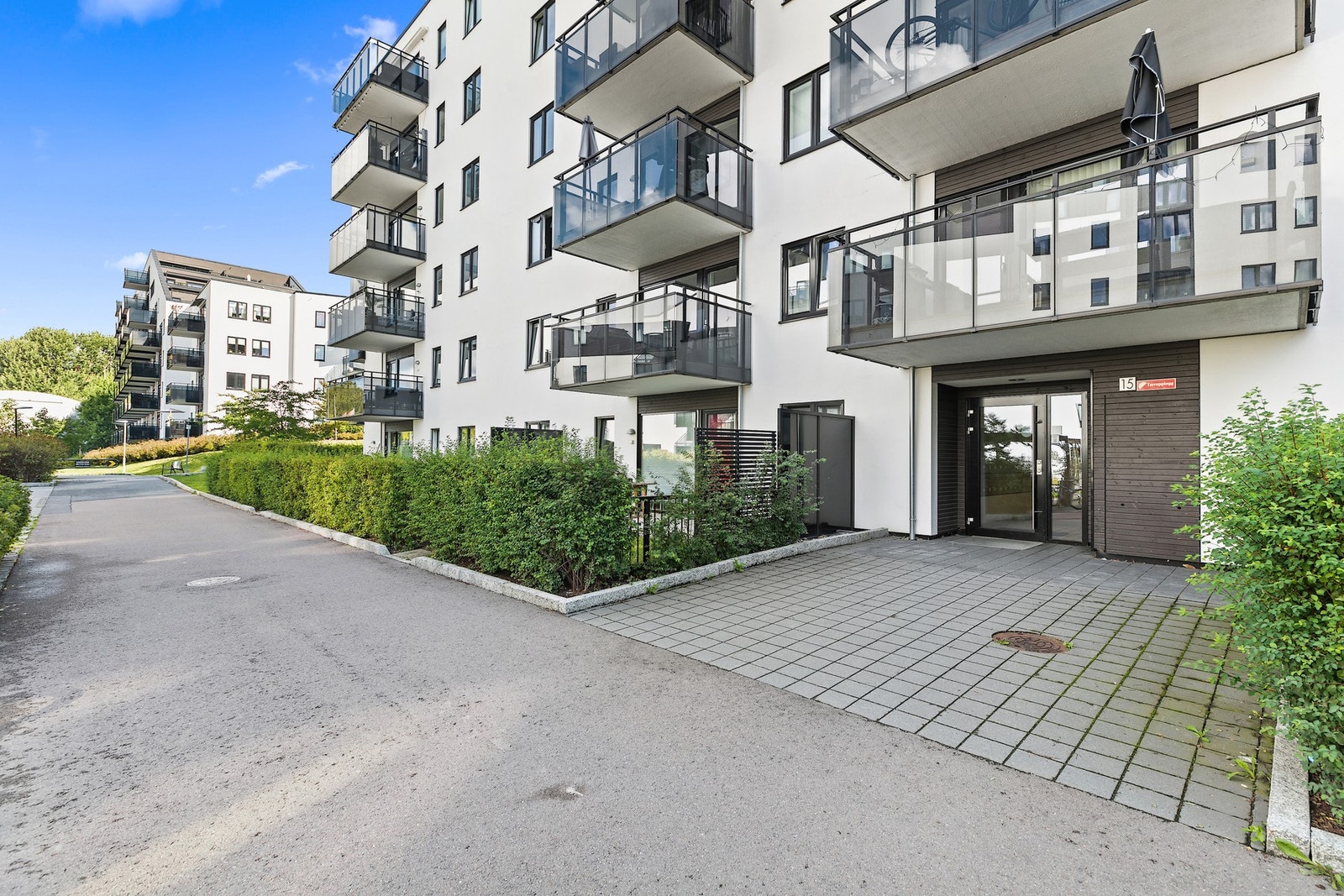 Leiligheten inngår i et moderne boligbygg med flere boenheter, med felles adkomst via et overbygget inngangsparti. Galleribilde