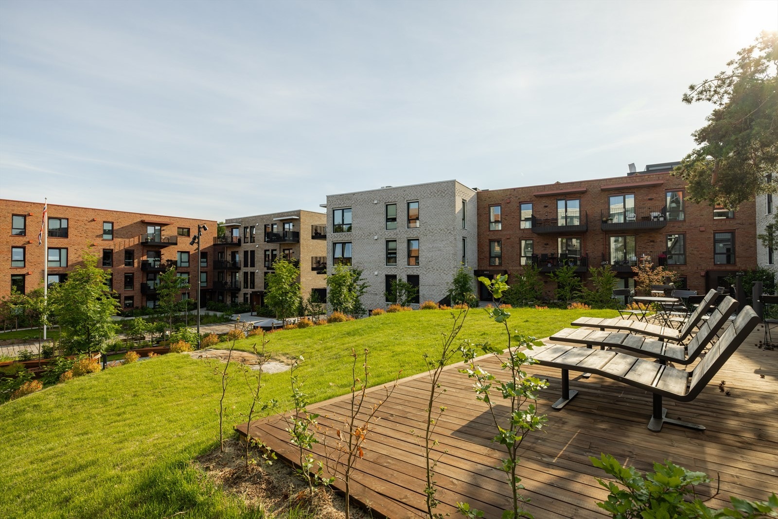 Den åpne bakgården er et flott samlingspunkt med lys og sol gjennom hele dagen - Det er også to gjesterom i bygg C som beboere kan booke inn til gjester Galleribilde