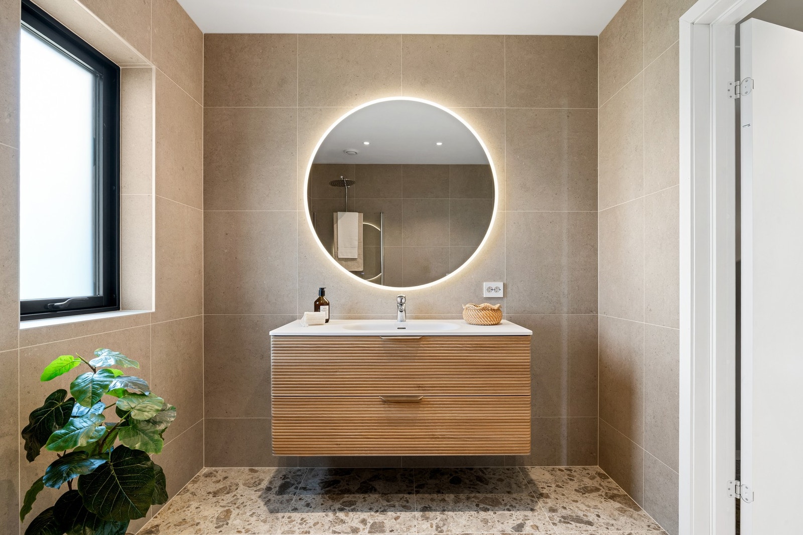 Servant, rundt speil m/ lys og antidugg, dusjnisje med "waterfall-dusj" og vegghengt toalett. Galleribilde