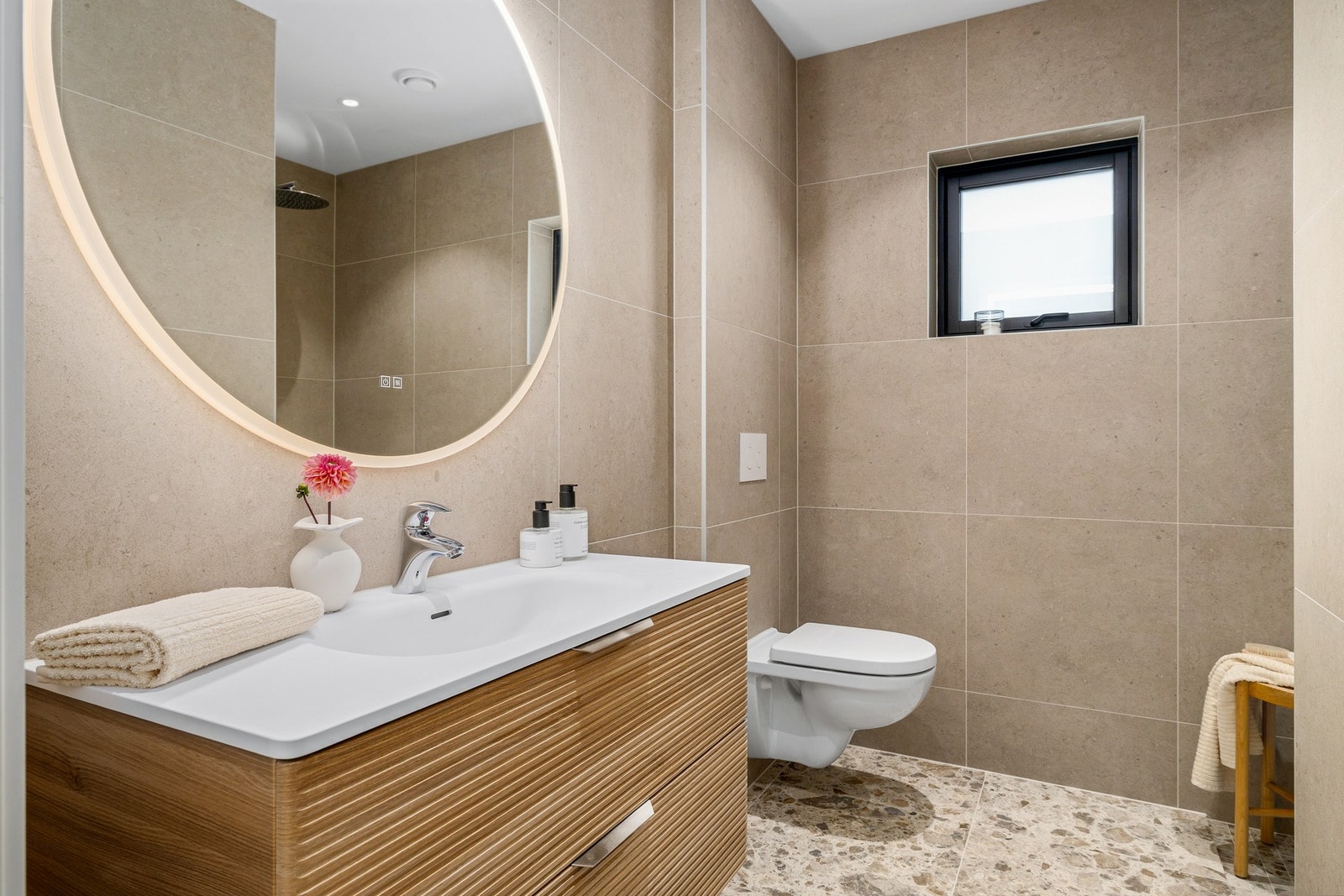 Varme i gulv, servant, rundt speil m/ lys og antidugg, dusjnisje med "waterfall-dusj" og vegghengt toalett Galleribilde