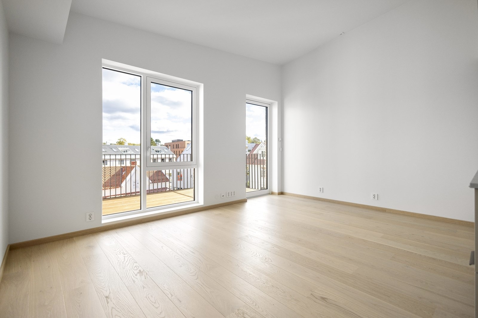 Leiligheten har en åpen stue-/kjøkkenløsning med plass til sofaseksjon, stuebord og spisebord Galleribilde