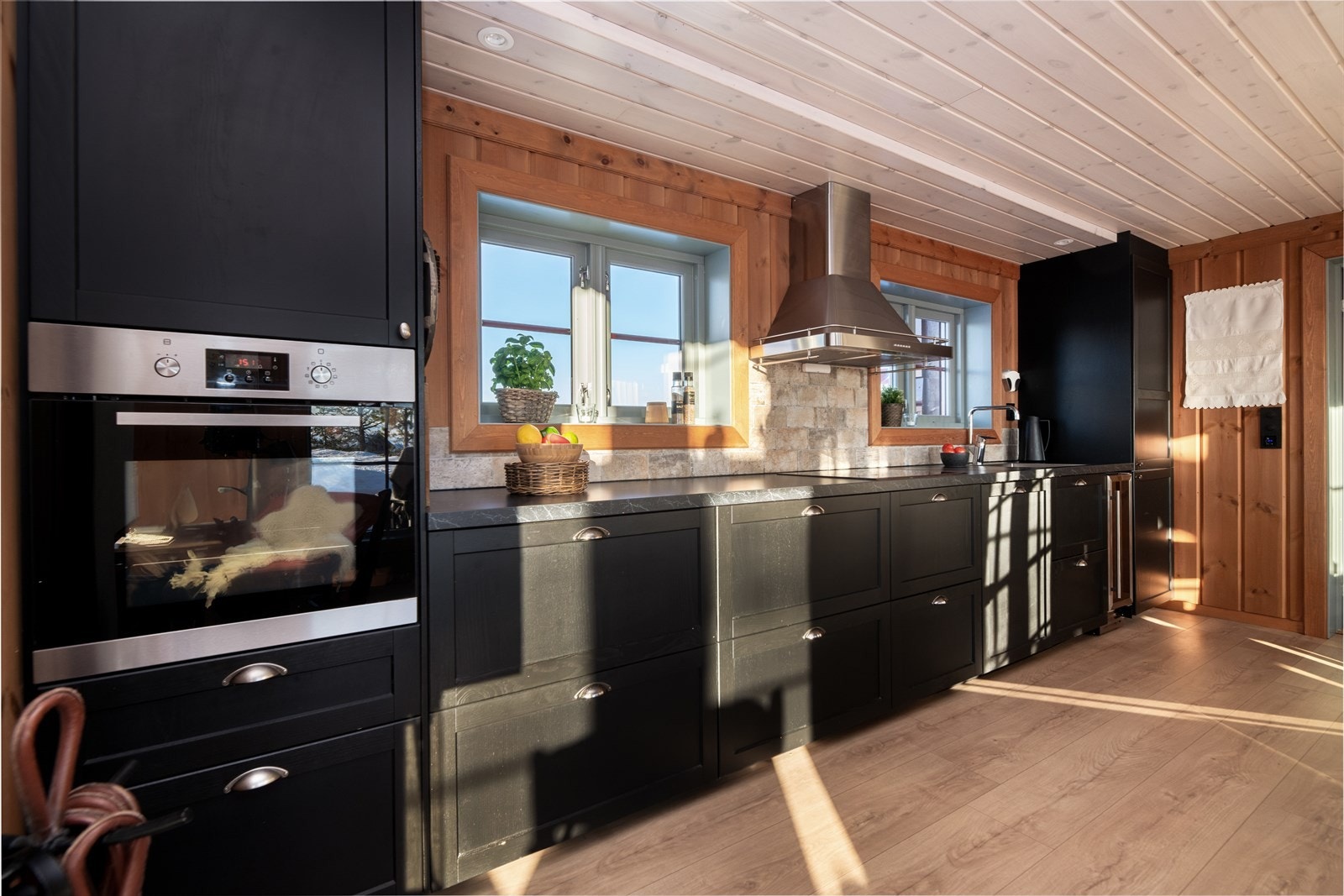 Kjøkkenet har stilig innredning med mørke fronter og takhøye skap som gir godt med skapplass. Galleribilde