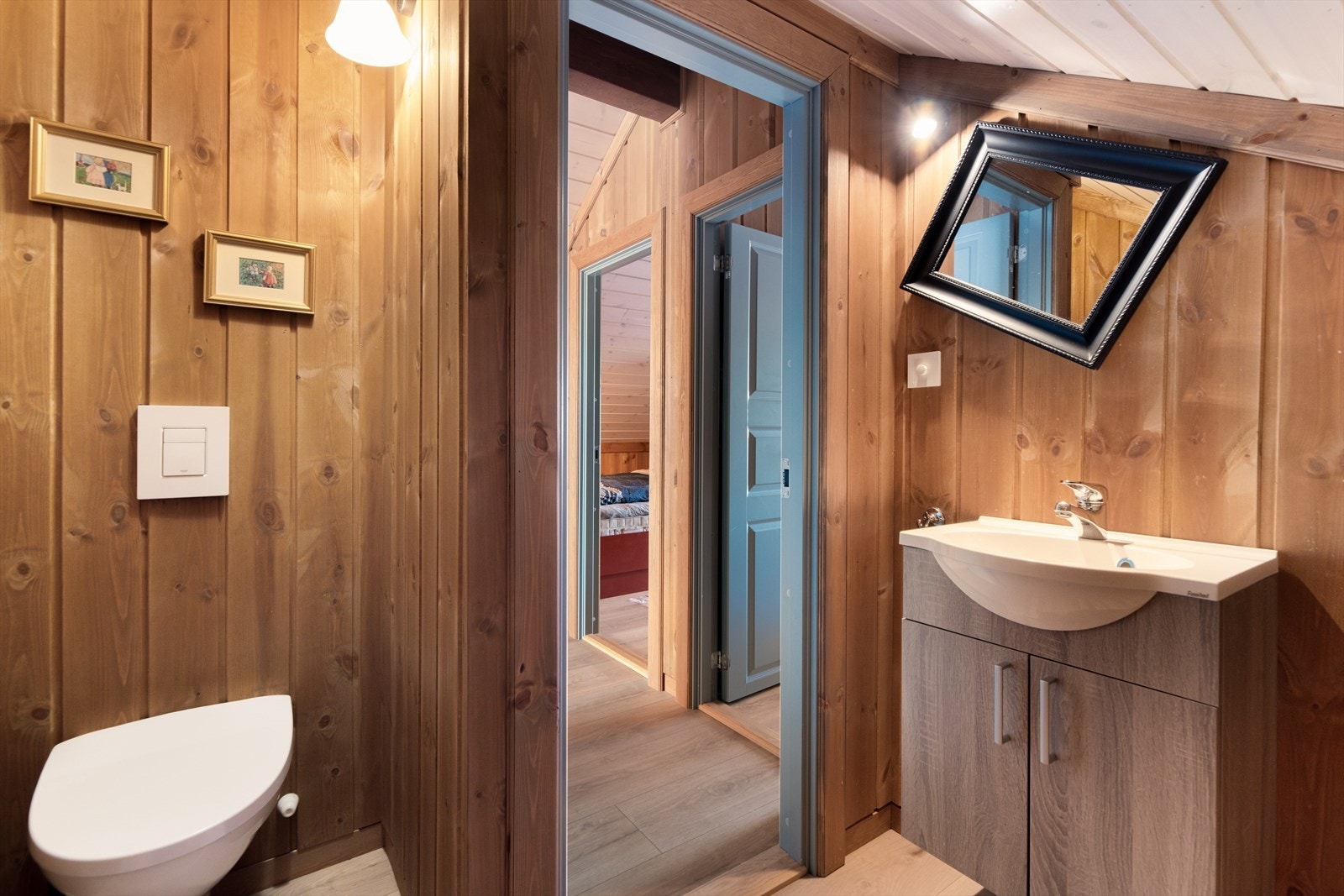 Toalettrommet innehar vegghengt toalett og servantinnredning med underskap. Galleribilde