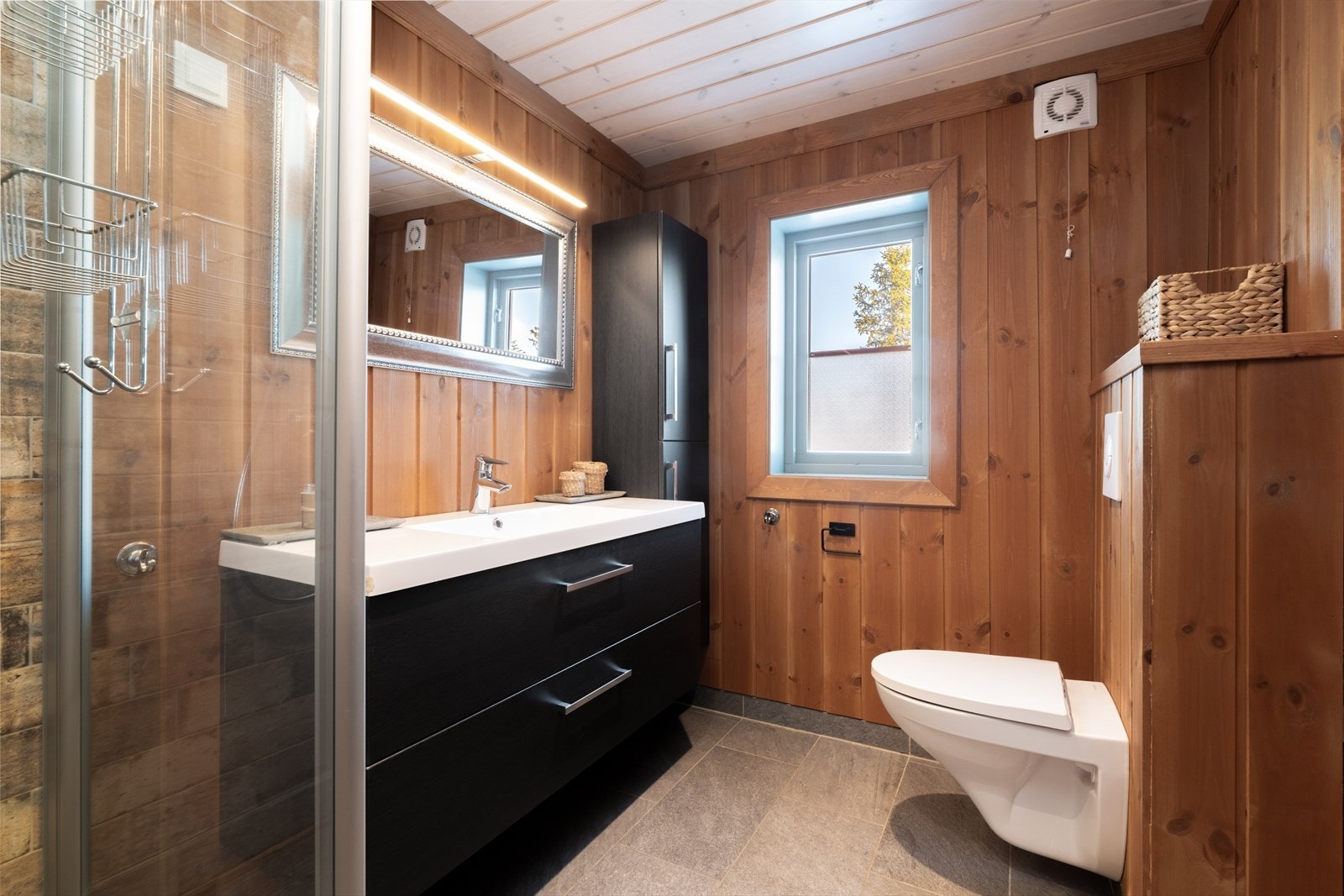 Det er i tillegg et eget baderom innafor hovedsoverommet. Dette badet har skifer på gulv med gulvvarme, panel på vegg med flis i dusjsone og panel i tak. Galleribilde