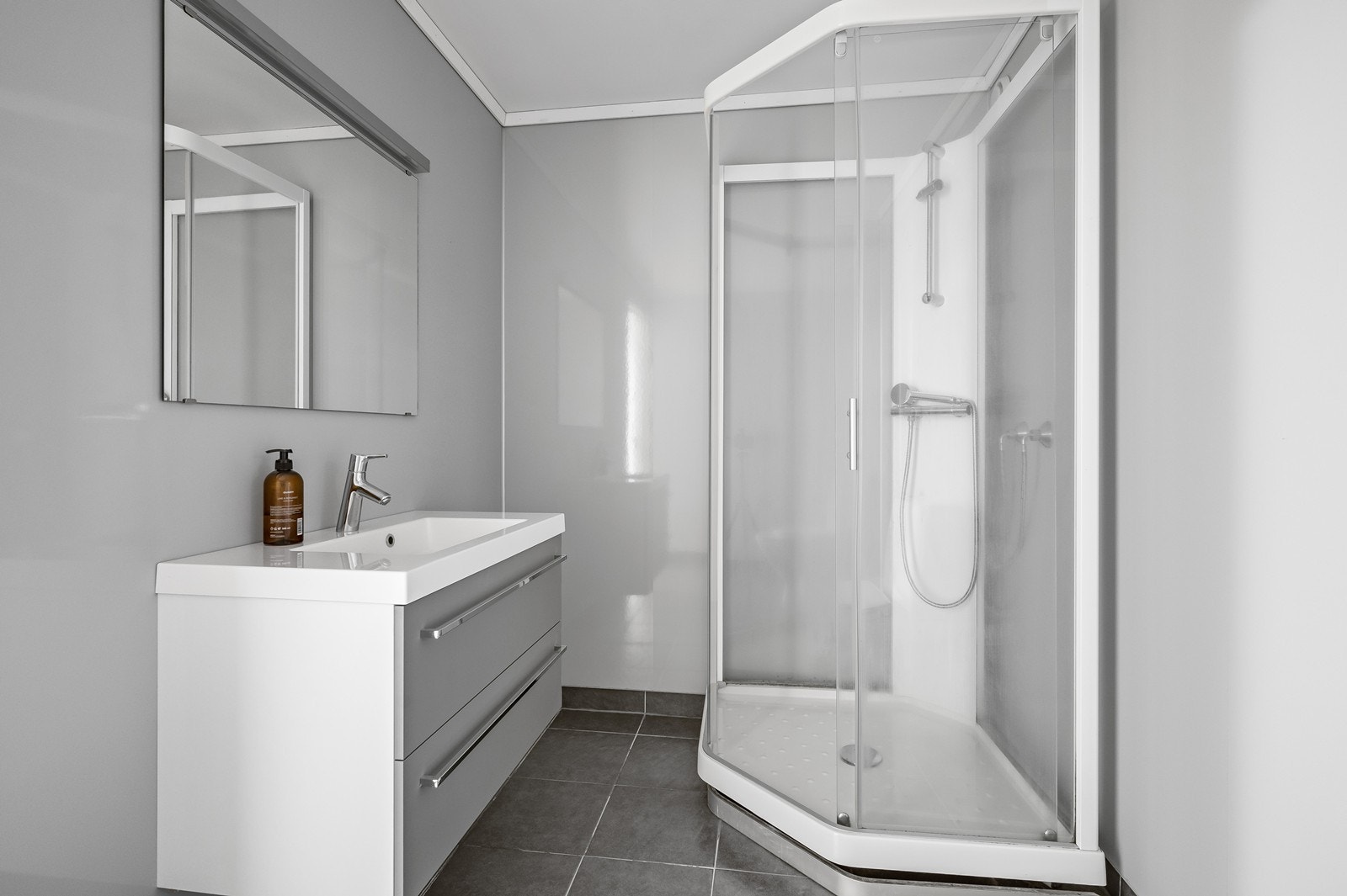 Badet har flislagt gulv med varmekabler, og våtromsplater på vegg. Galleribilde