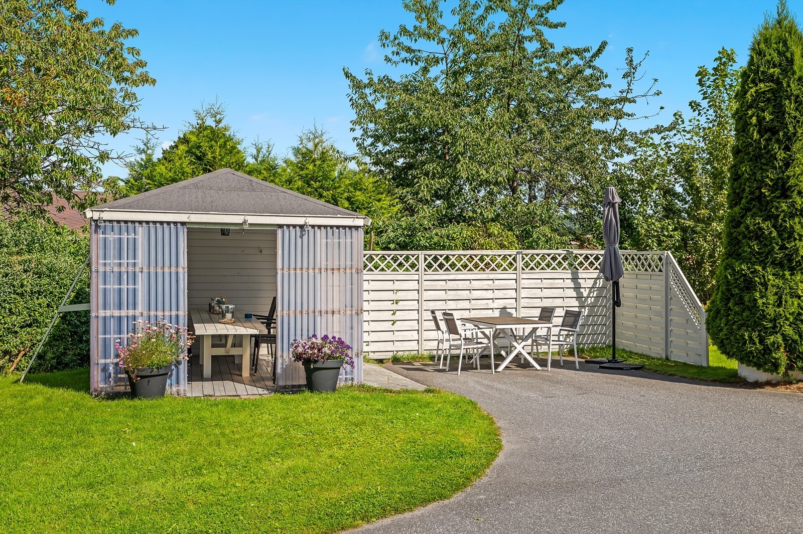 Felles uteområde er opparbeidet med gressplen og spredt beplantning med blomster og busker. Galleribilde
