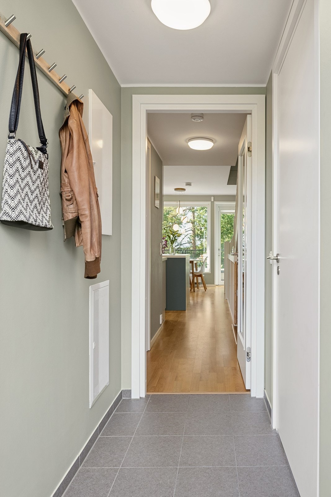 Inngangen møtes man av en flislagt gang med vannbåren gulvvarme. Her er det god plass til å henge fra seg yttertøy og sette fra seg sko. Galleribilde