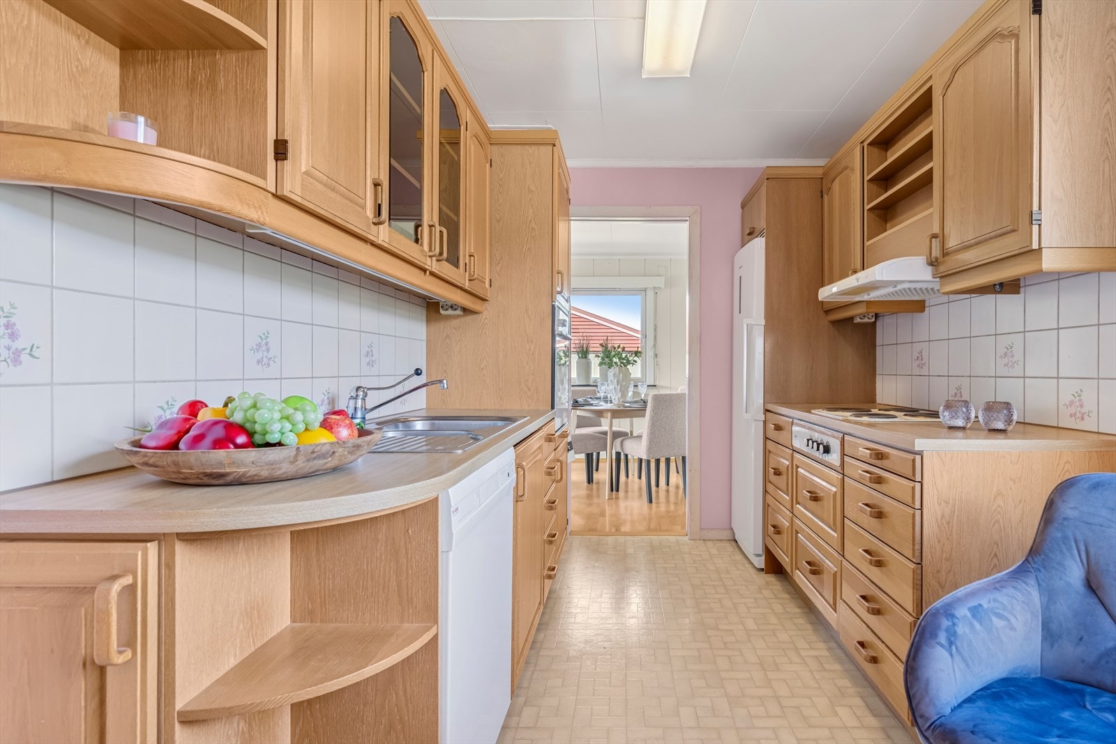 Kjøkkenet har innredning med profilerte eike fronter. Benkeplaten er av laminat. Fliser på vegg over benkeplaten. Galleribilde