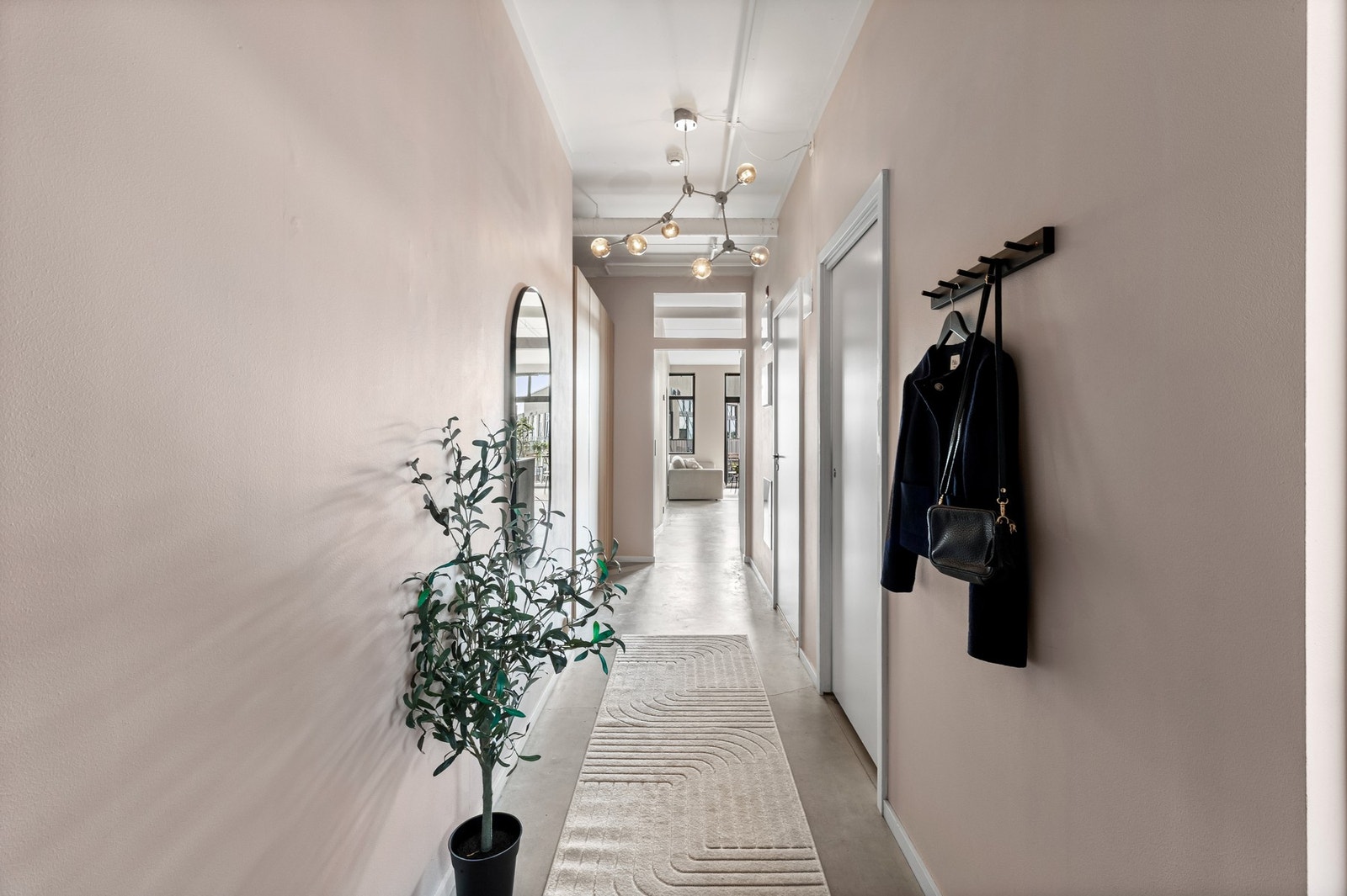 Romslig og innbydende entré med originale betonggulv og lyse vegger som skaper en luftig atmosfære. Galleribilde