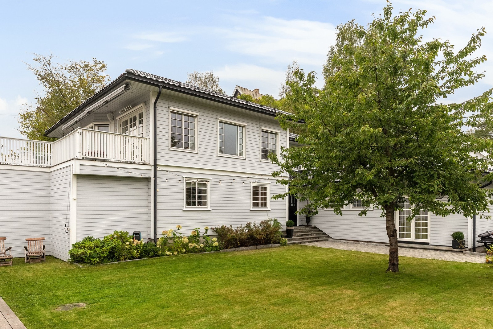 Plenen foran huset er hevet over veien og oppleves usjenert. Fint innrammet av den nye sommerstuen med pergola Galleribilde