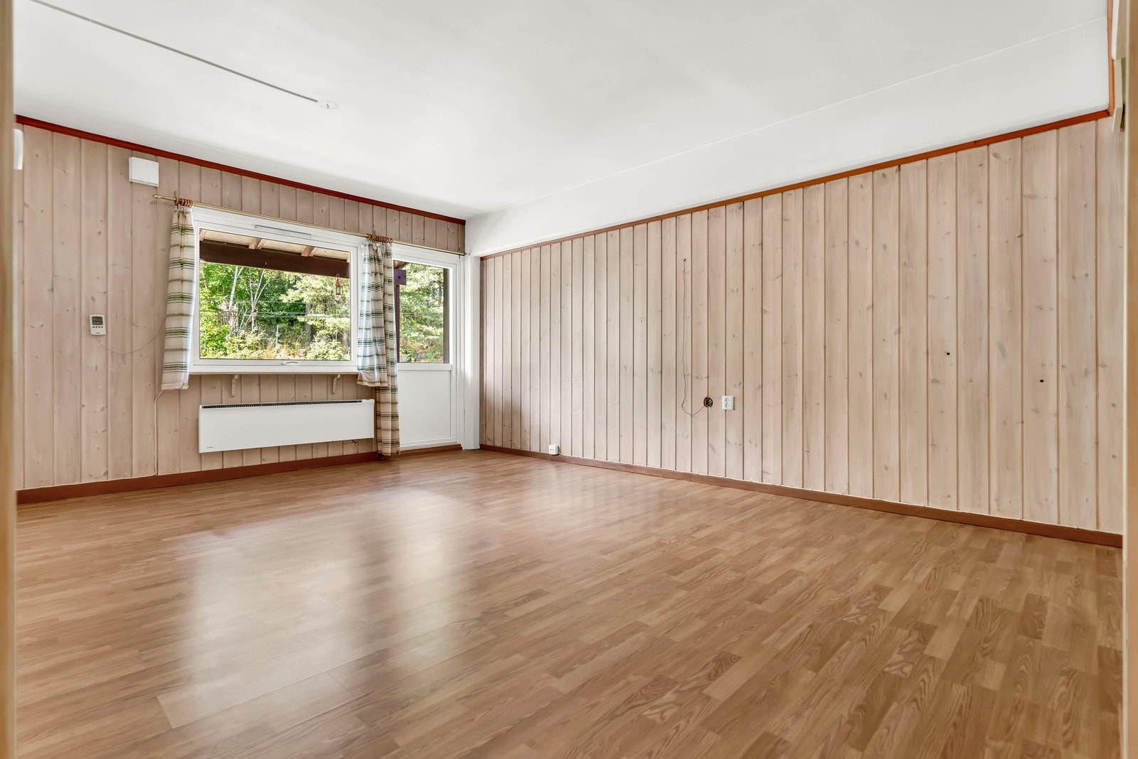 Velkommen inn i stuen - Klassisk trepanel kombinert med store vindusflater gir rommet en lys og innbydende atmosfære. Galleribilde