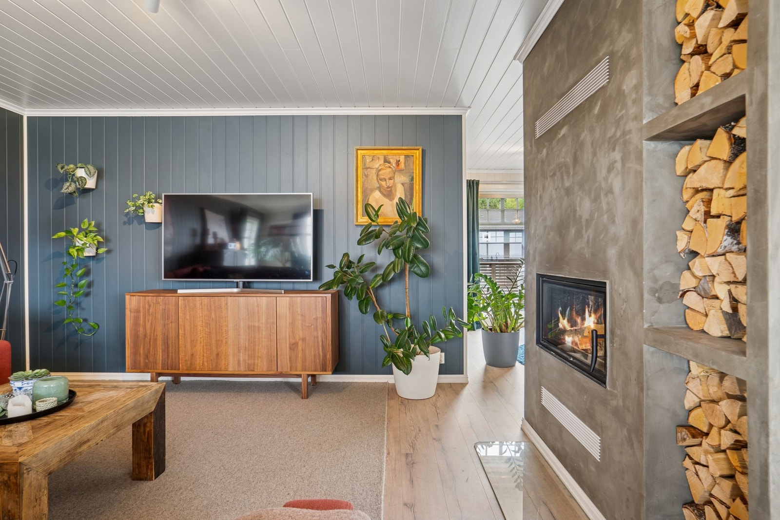 Stuen byr på en lun atmosfære med peisen som blikkfang, og gir rom for både avslapping og hyggelige kvelder foran TV-en. Galleribilde