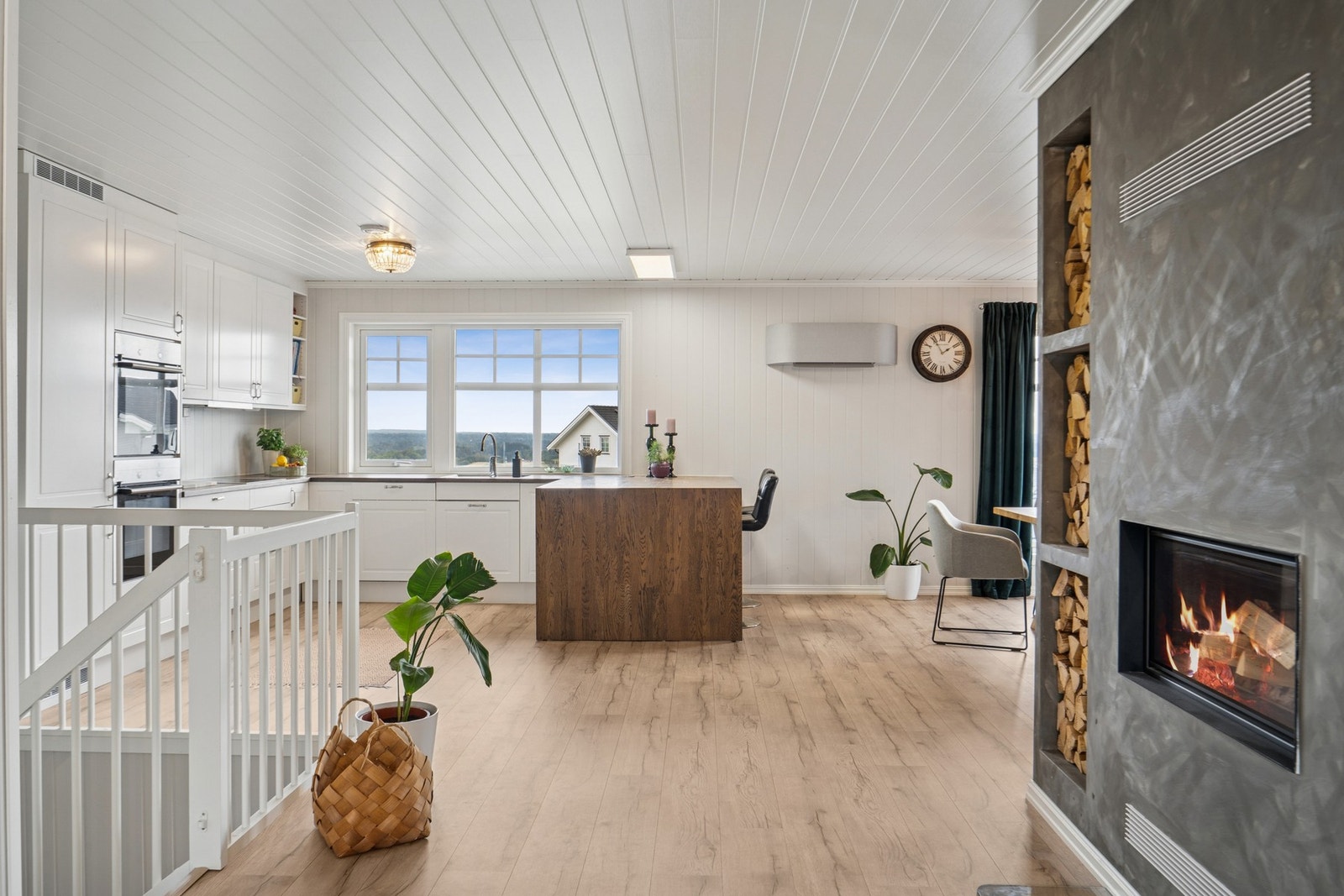 Velkommen inn! Boligen har en romslig og åpen planløsning som sømløst binder sammen kjøkken og oppholdsrom, og legger til rette for både hverdagsliv og hyggelige stunder foran peisen. Galleribilde