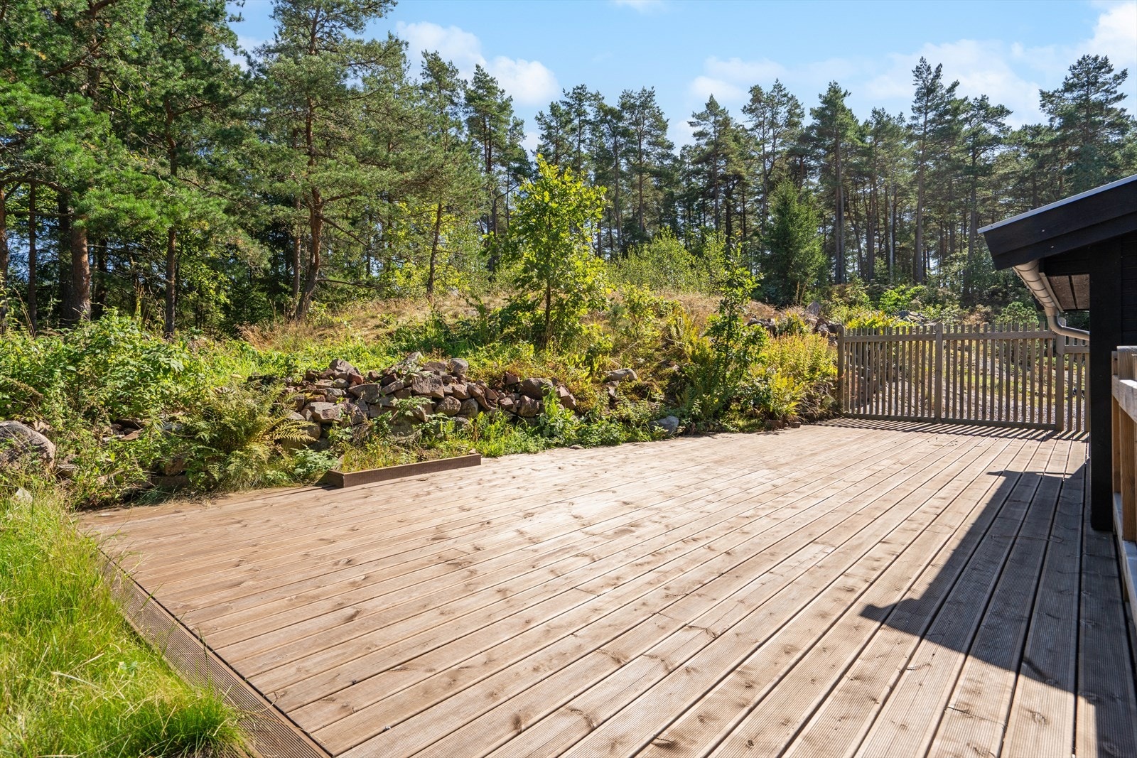 Det er anlagt stor terrasseplatting på baksiden av boligen mot skogen. Galleribilde