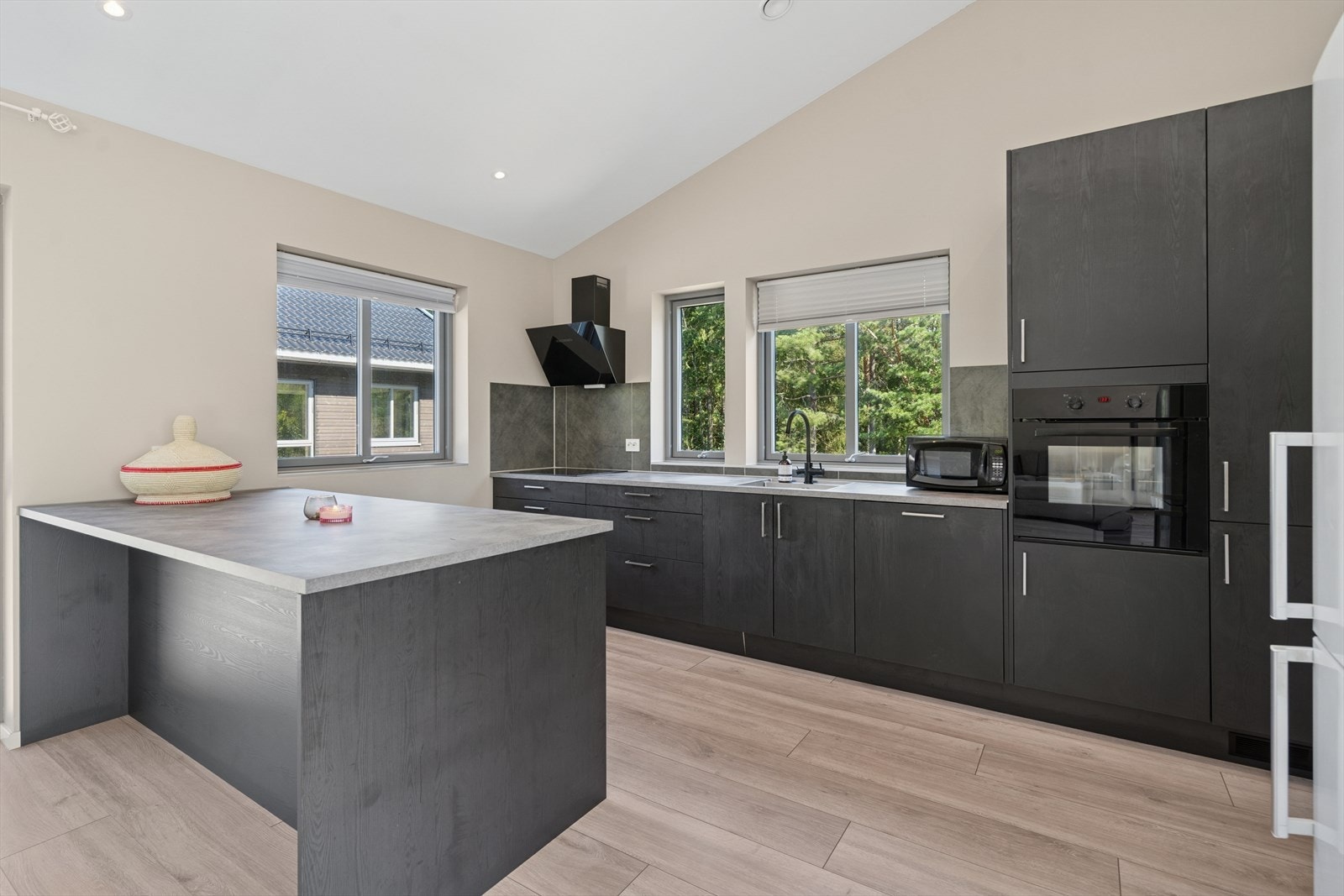 Kjøkkenet blir avgrenset mot stuen av en praktisk kjøkkenøy hvor benkeplaten kan brukes som en praktisk barløsning for et raskt frokostmåltid. Galleribilde