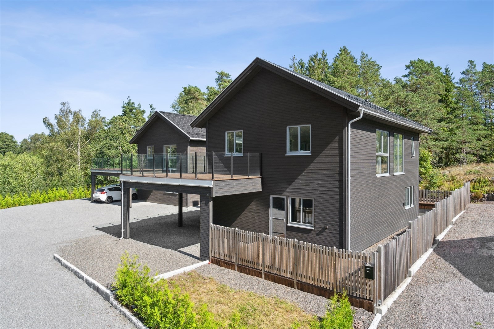 Boligen har en stor carport med overbygget tak frem til inngangspartiet. Opparbeidet parkeringsplass ved siden av carporten. Galleribilde