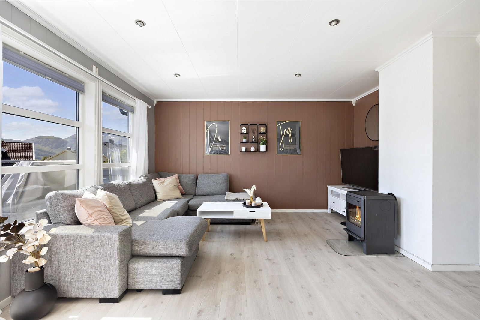 Lun stue med store vinduer, vedovn og overflater utført i tidsriktige farger Galleribilde