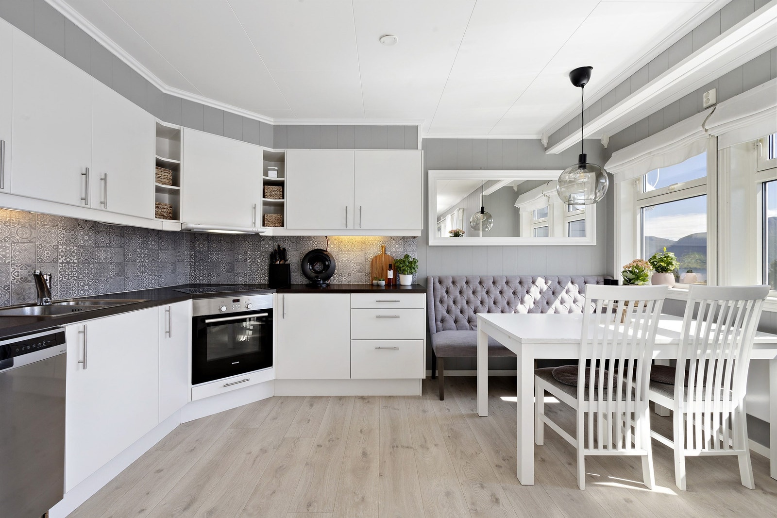 Stilrent kjøkken med moderne fronter, noen integrerte hvitevarer og god skap- og benkeplass Galleribilde