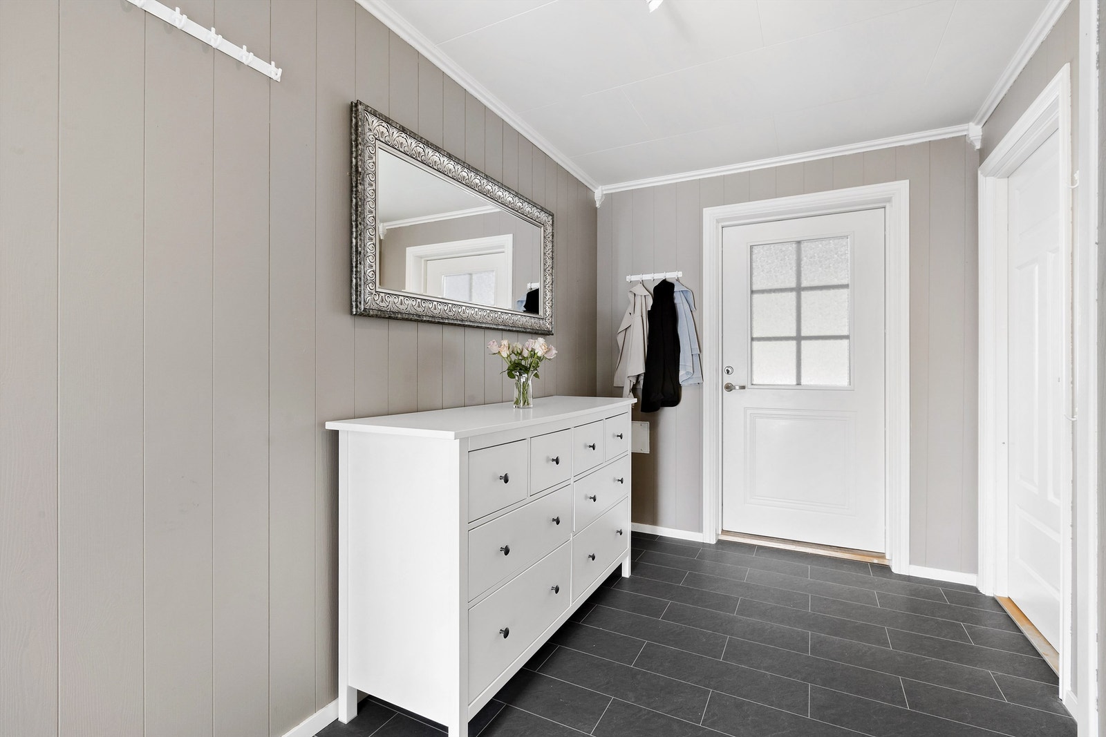 Romslig entré med praktiske løsninger for oppheng og lagring Galleribilde