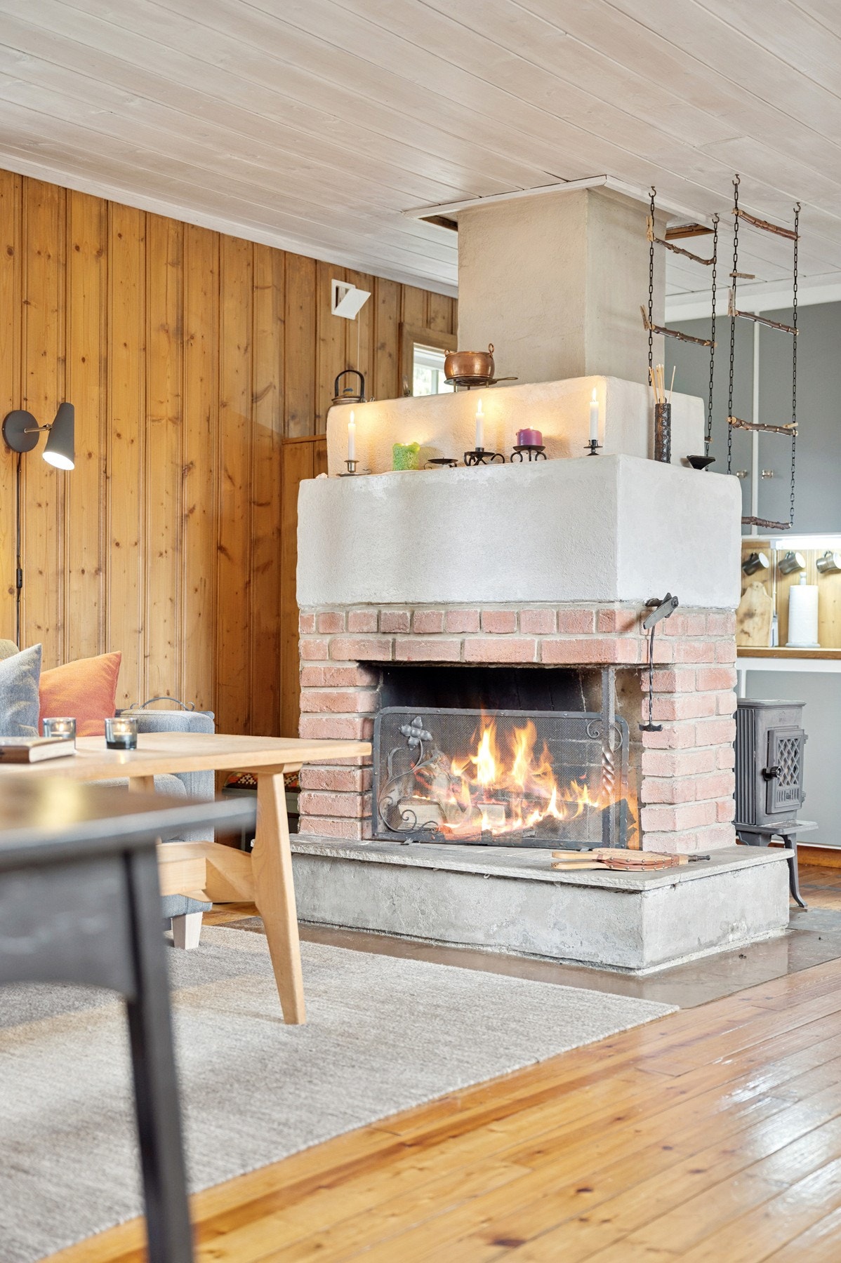 Midtpunktet i rommet er den åpne peisen, som ikke bare varmer på kalde dager, men også skaper den lune og autentiske hyttefølelsen. Galleribilde