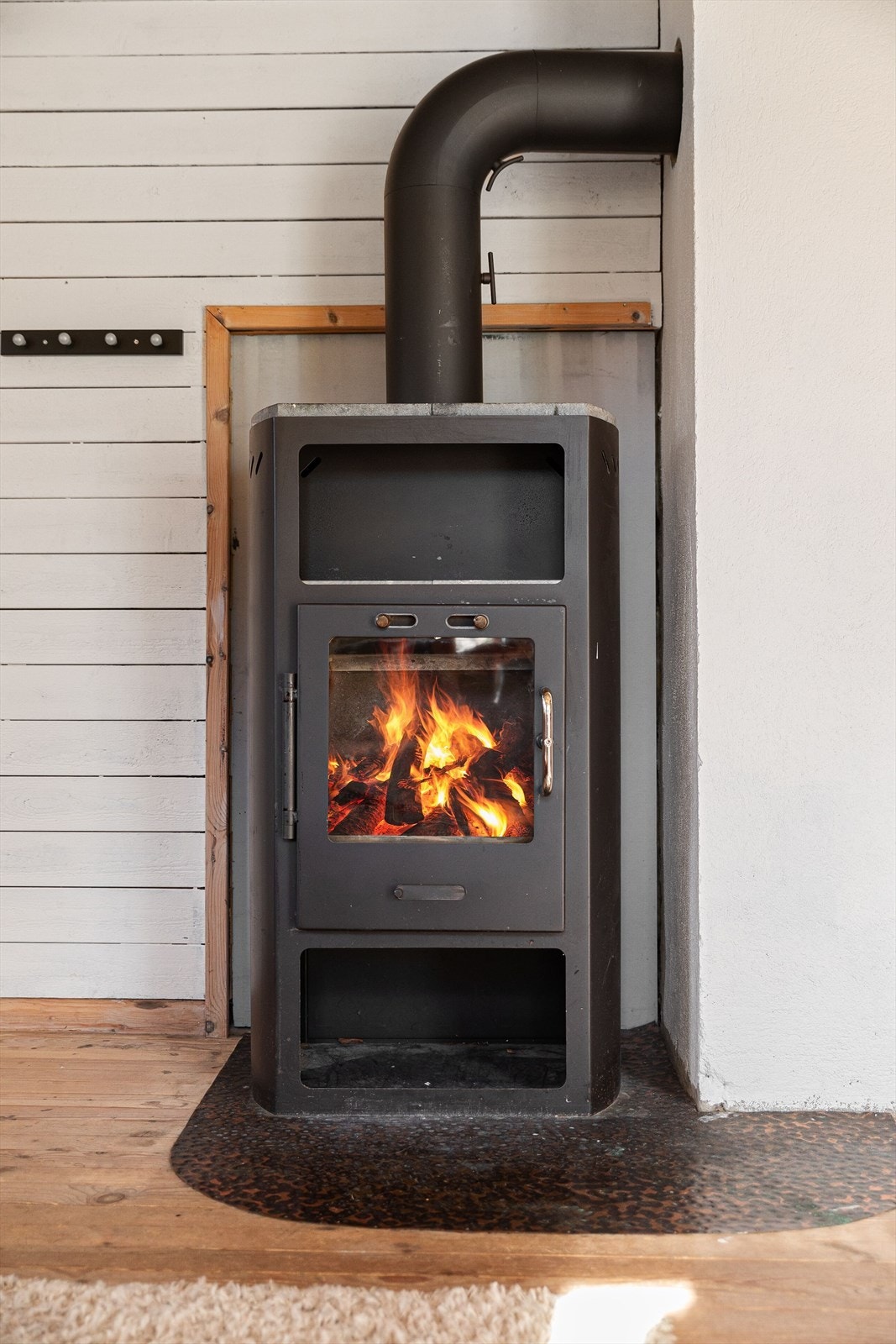 En vedovn er sentralt plassert i stuen og gir både varme og en lun atmosfære. Galleribilde