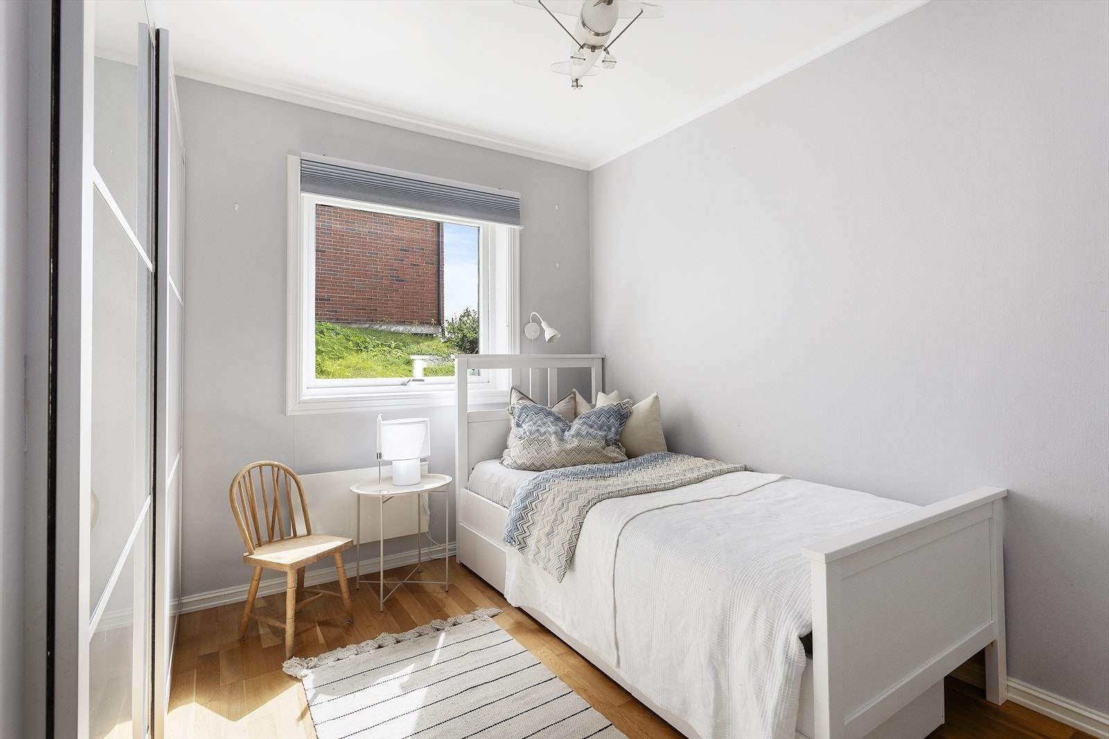 Boligens tredje soverom er innredet med en skyvedørsgarderobe for god oppbevaring. Store vindusflater gir en luftig følelse. Galleribilde