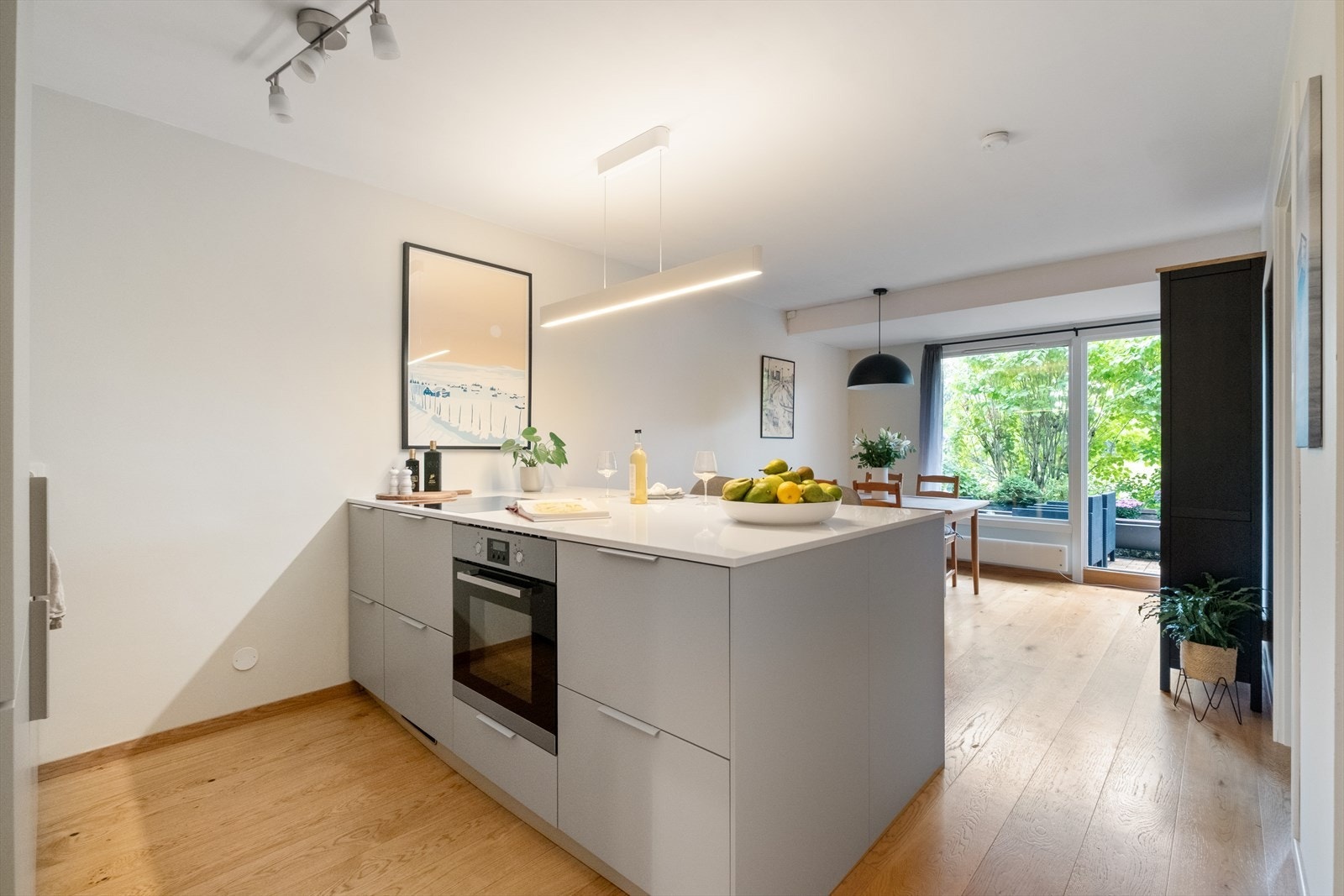 Videre har leiligheten en smart planløsning med åpen løsning mellom kjøkken, spiseplass og stue, som skaper en sosial og luftig atmosfære Galleribilde