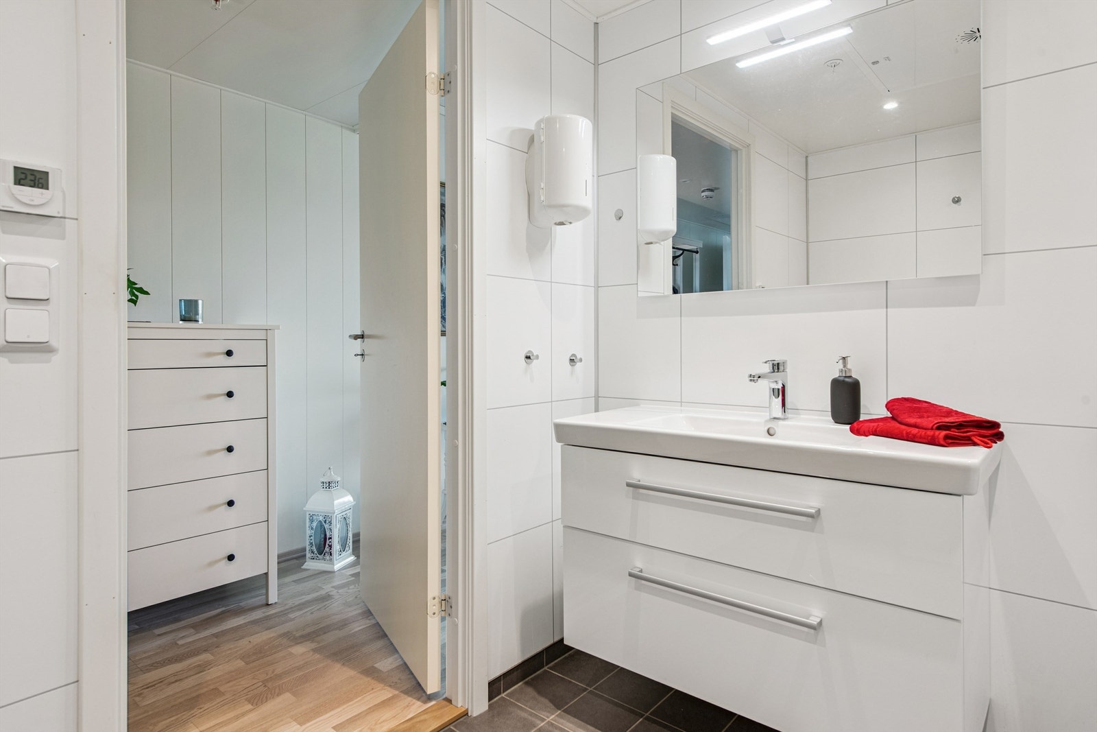 Lyst og pent baderom med flis på gulv og baderomsplater på veggene. Galleribilde