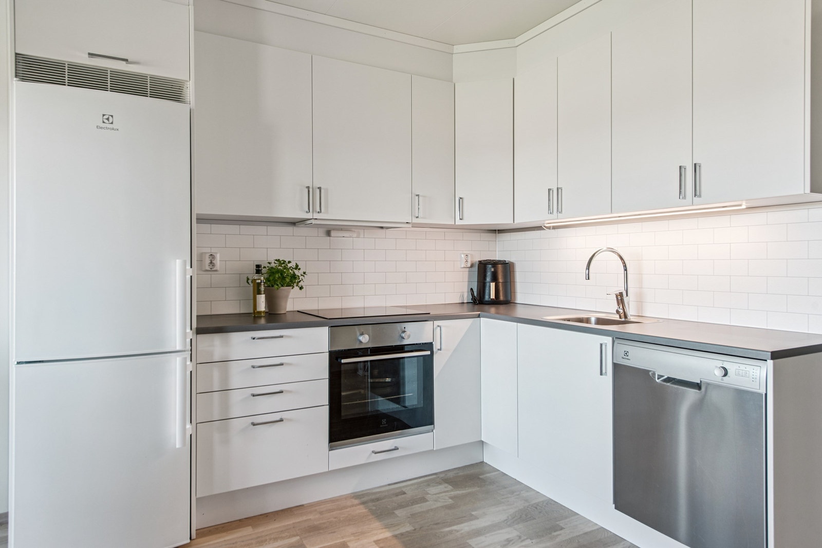 Kjøkkeninnredning med integrert koketopp, stekeovn, oppvaskmaskin og kjøl/fryseskap. Galleribilde