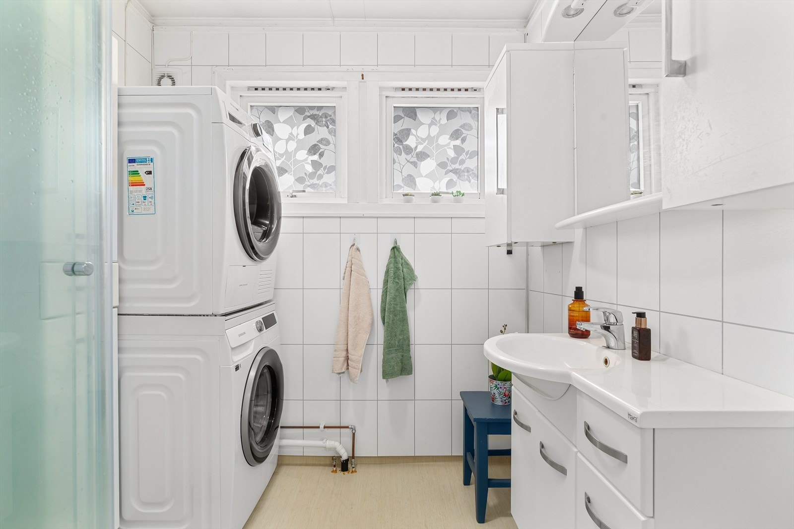 Lyst og pent bad med opplegg for vaskemaskin og tørketrommel. Innredningen er bestående av dusjkabinett og baderomsinnredning med speil og sideskap Galleribilde