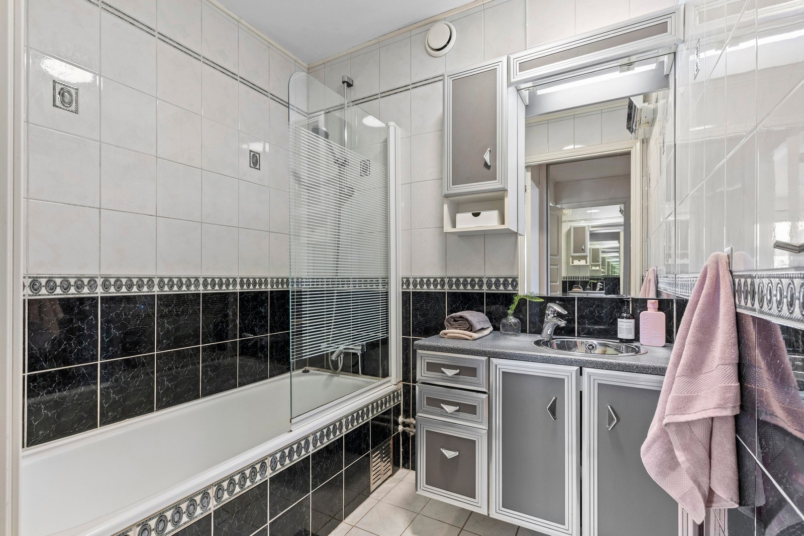 Badet har flislagte vegger og gulv, samt en himling med sparklet og malt overflate Galleribilde