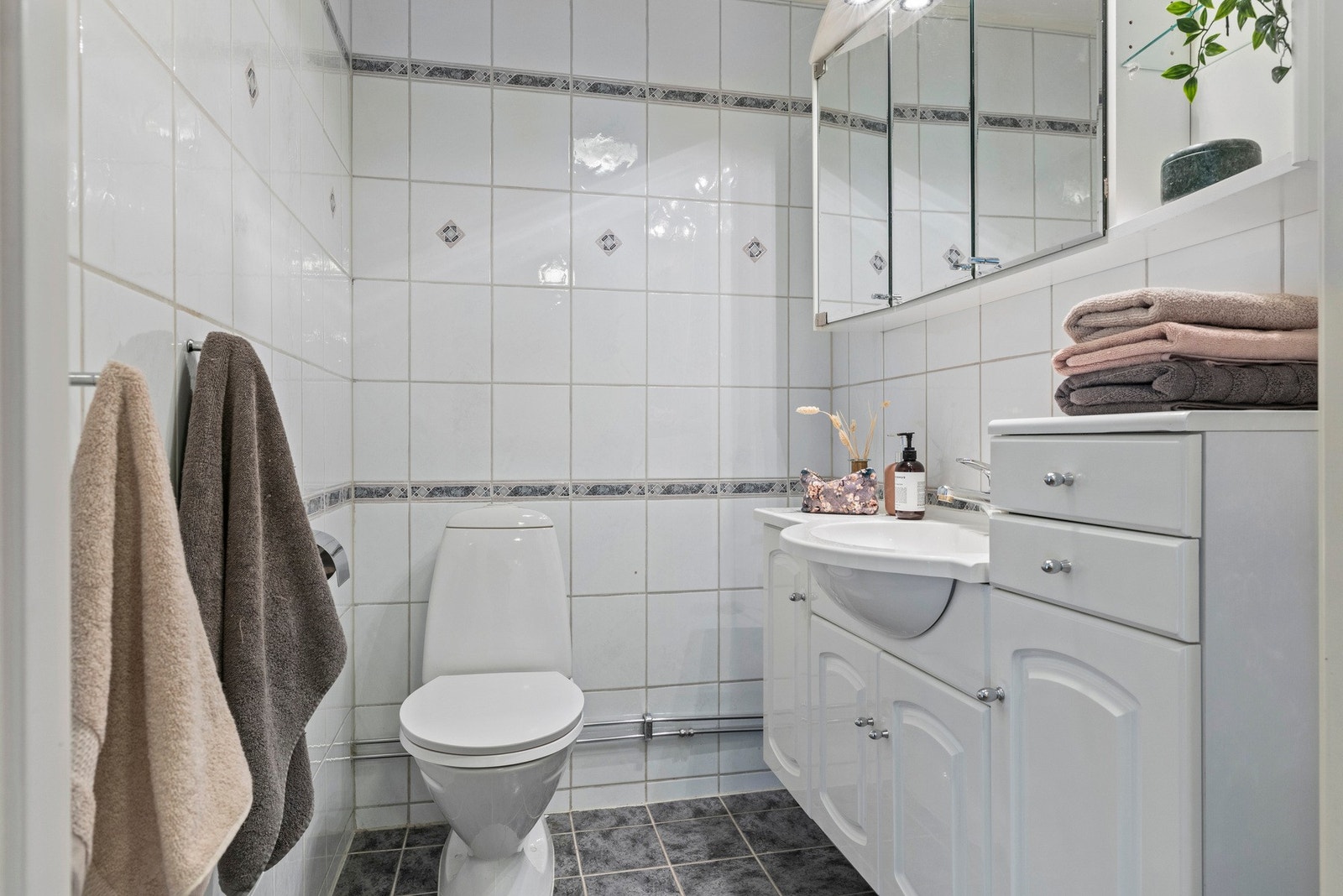 Toalettrommet har et gulvstående toalett og innredning med profilerte fronter Galleribilde