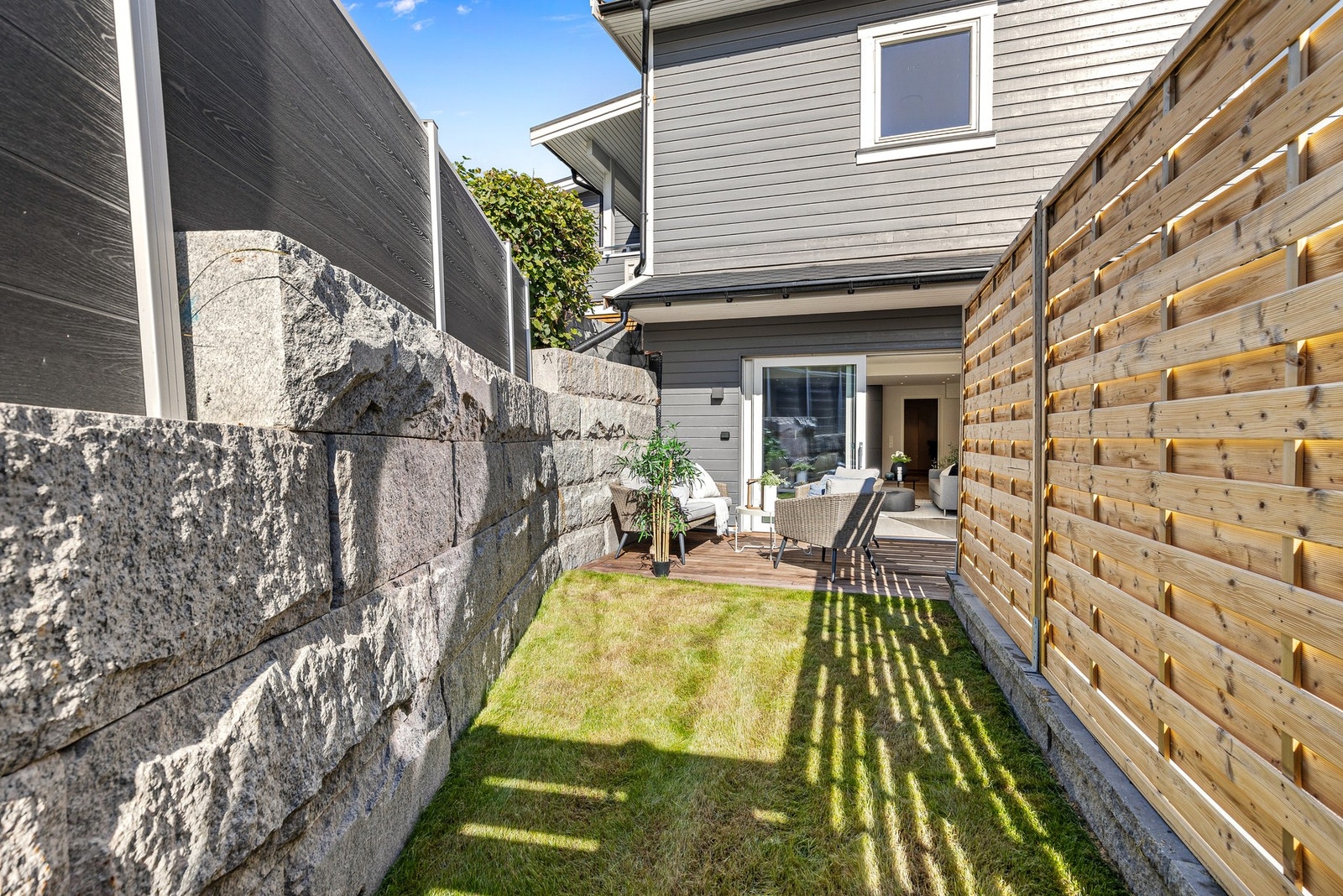 Uteplassen er godt skjermet av levegg og støttemur Galleribilde