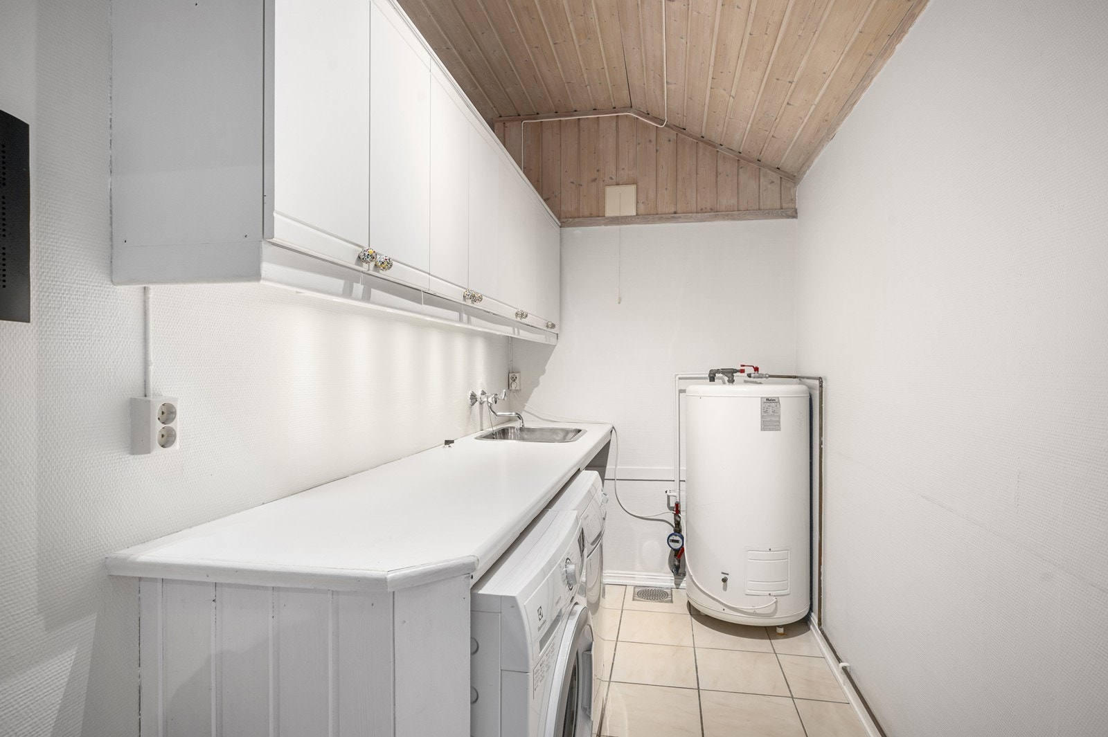 Vaskerom i bakkant av kjøkken - Praktisk innredning, godt med skap og benkeplass. Galleribilde