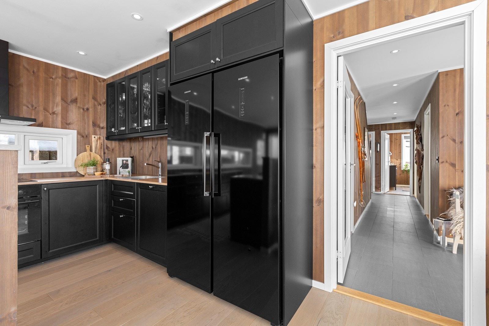 Eksklusivt sort kjøkken med integrerte hvitevarer og stilige detaljer Galleribilde