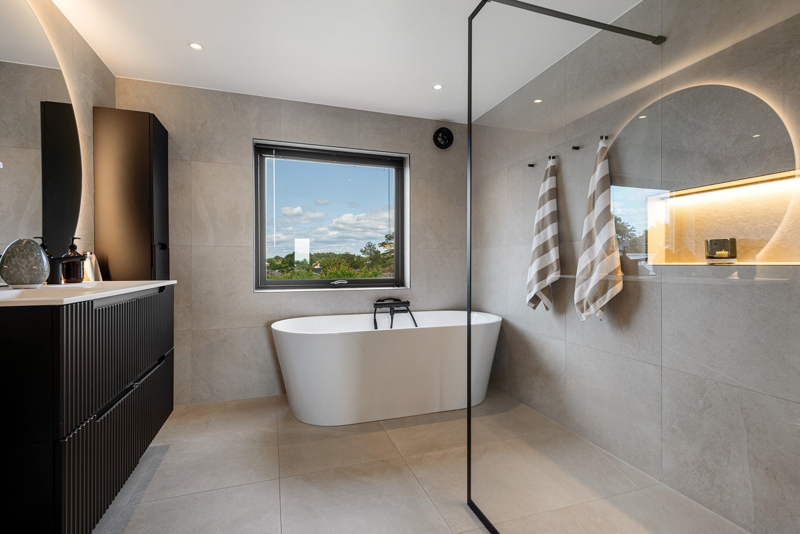 Lekkert flislagt bad med praktiske løsninger, god kvalitet og fine detaljer. Galleribilde