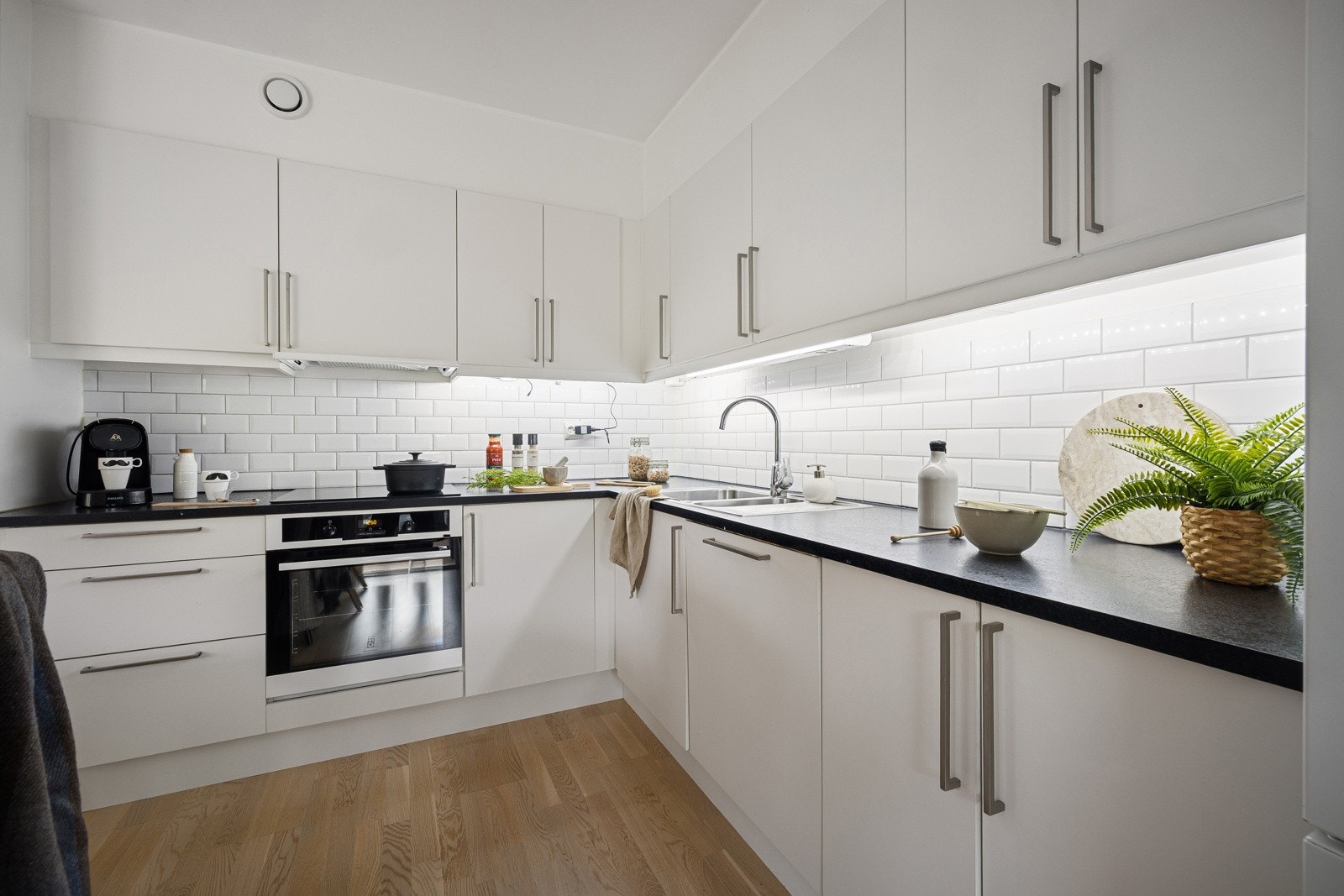 Praktisk med fliser over kjøkkenbenken og god arbeidsplass på benkeplaten som er av laminat. Galleribilde