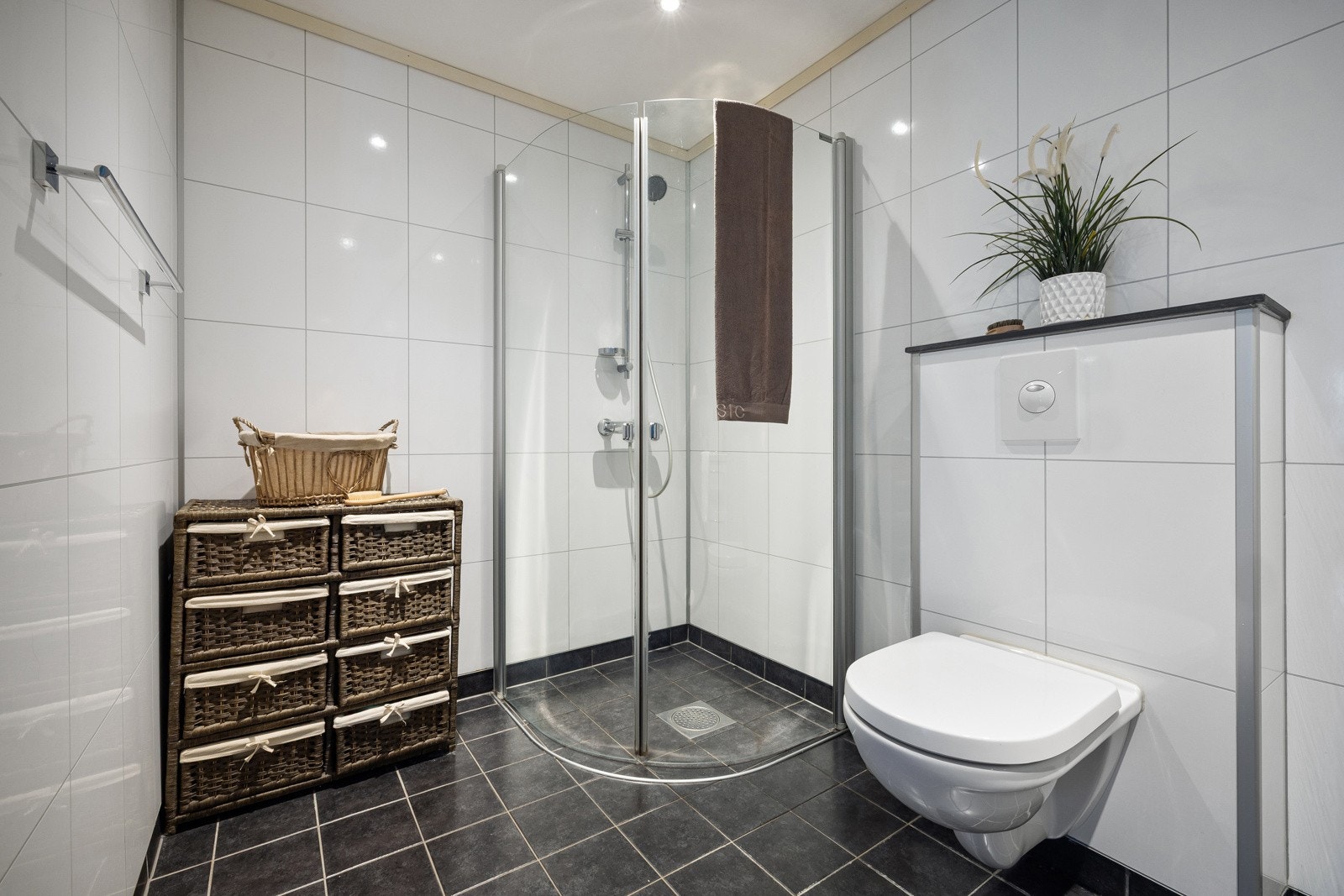 Badet har flislagt gulv med elektriske varmekabler og baderomsplater på veggene. Galleribilde