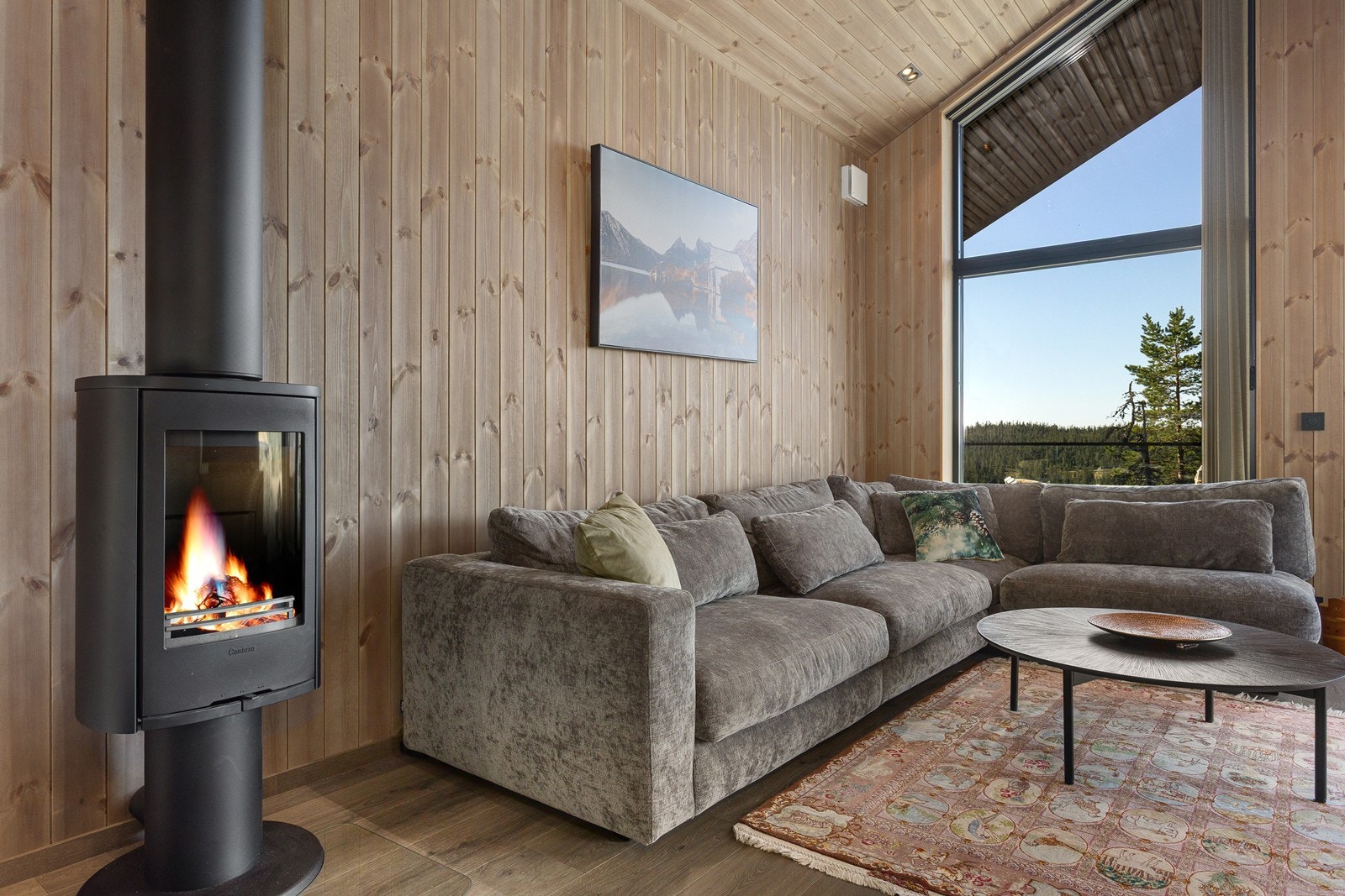 I stuen er det også en vedovn som både varmer og skaper hyggelig stemning, og dimbare downlights sikrer god og stemningsfull belysning. Galleribilde