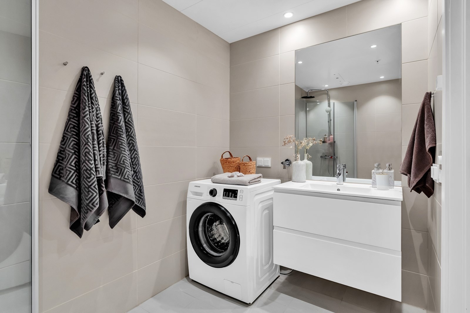 Badet er stilig og funksjonelt, med moderne fliser og kvalitetsinnredning Galleribilde