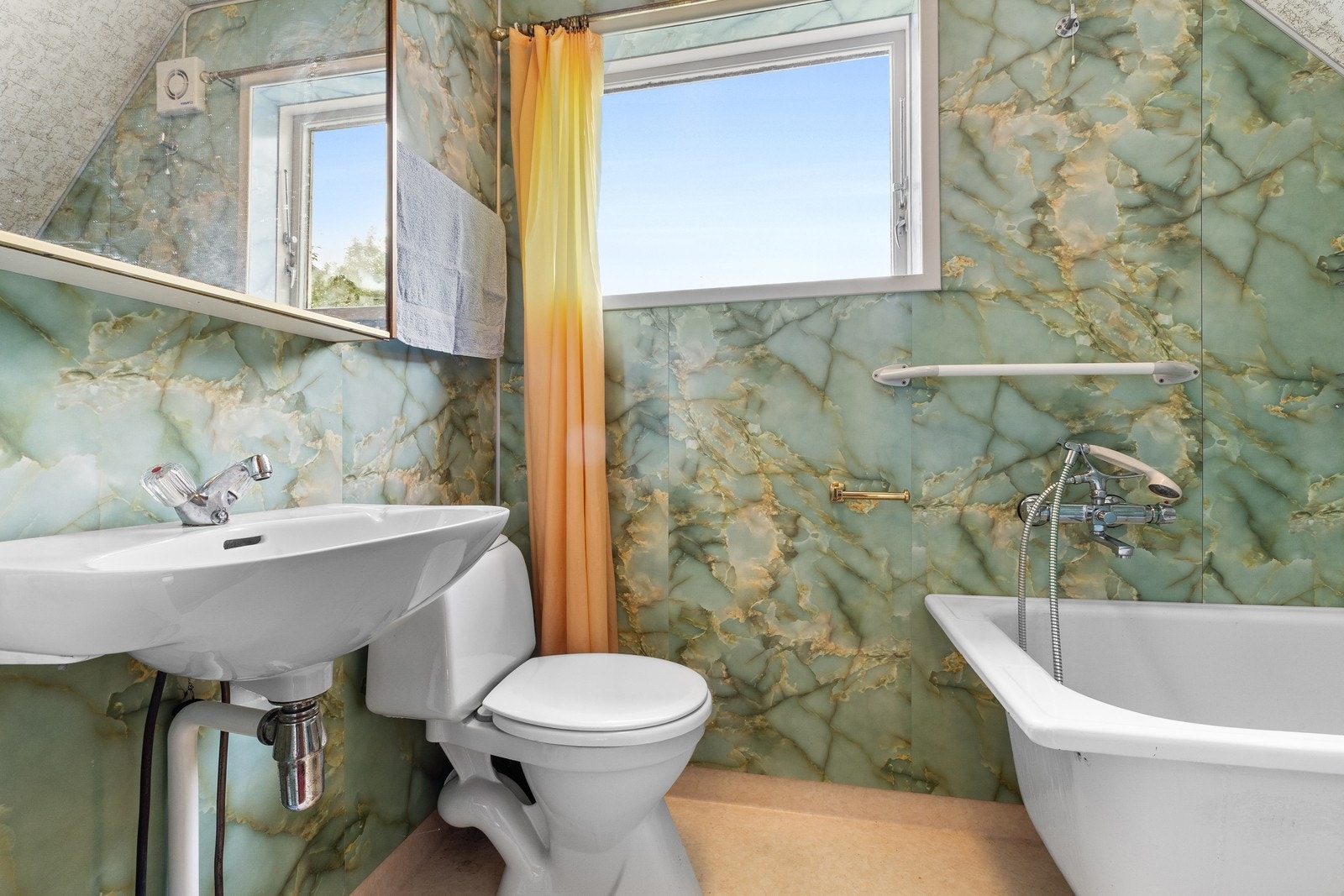 Badet er innredet med badekar, servant og gulvstående toalett. Galleribilde
