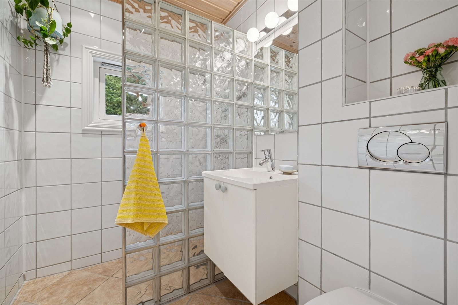 Badet er et lyst og praktisk og er innredet med nedfelt servant, vegghengt toalett og dusj. Galleribilde