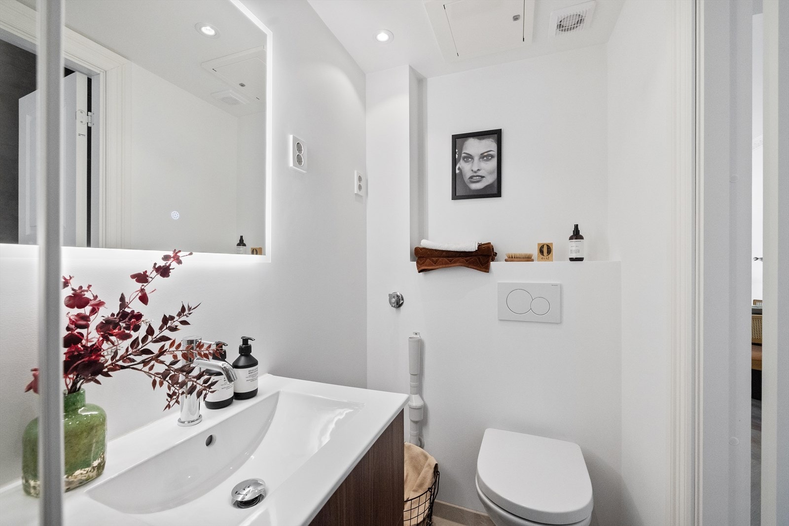 Innredning bestående av vegghengt toalett, servant med skuffer, dusjhjørne med glassdør og opplegg for vaskemaskin. Galleribilde