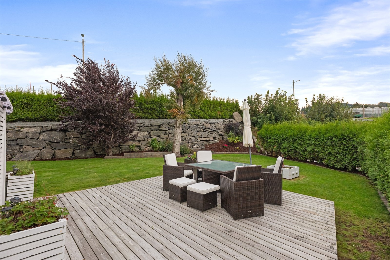 Pent opparbeidede uteplasser med gode solforhold. Plen, terrasser og beplantning. Galleribilde