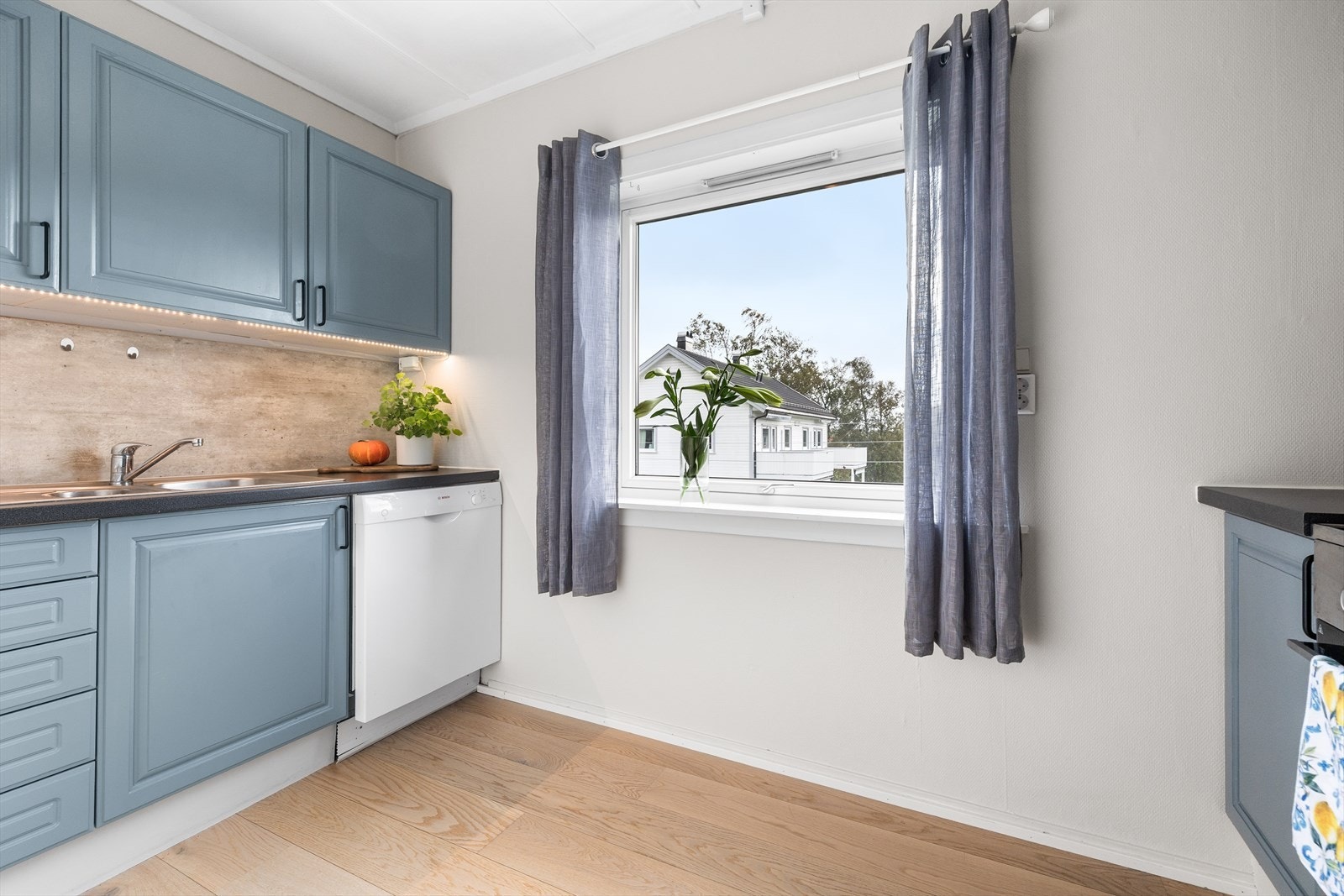 Kjøkkenet er praktisk utformet og gir rom for både matlaging og hyggelige måltider. Laminat på gulv, malt glassfiberstrie på vegger og malte plater i himling. Galleribilde