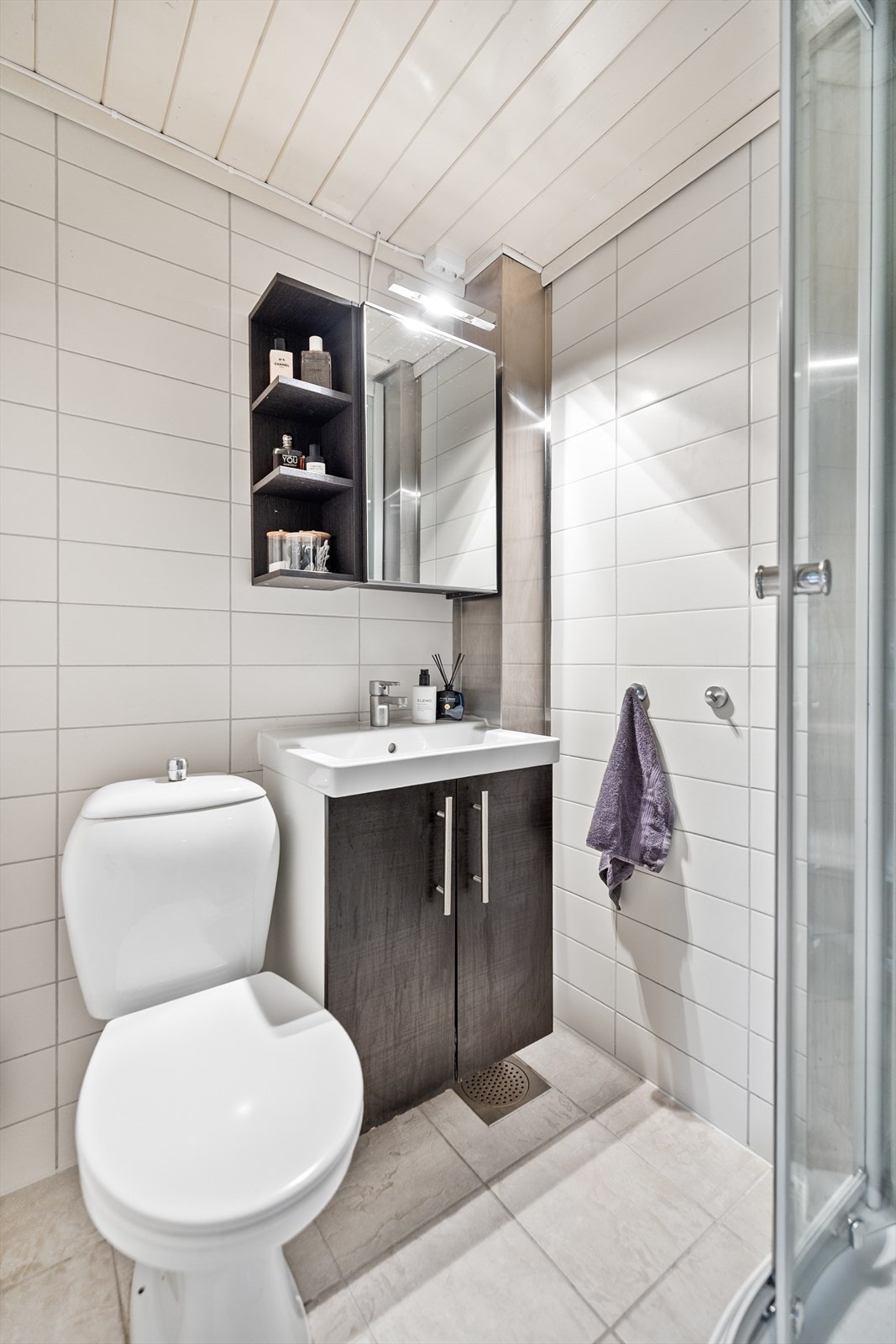 Veggene er helfliset, og himlingen har malt panel som gir et rent og pent uttrykk. Rommet er praktisk innredet med nedfelt servant i innredning, toalett og dusjkabinett. Her er det lagt vekt på funksjonalitet og en tidløs utforming. Galleribilde