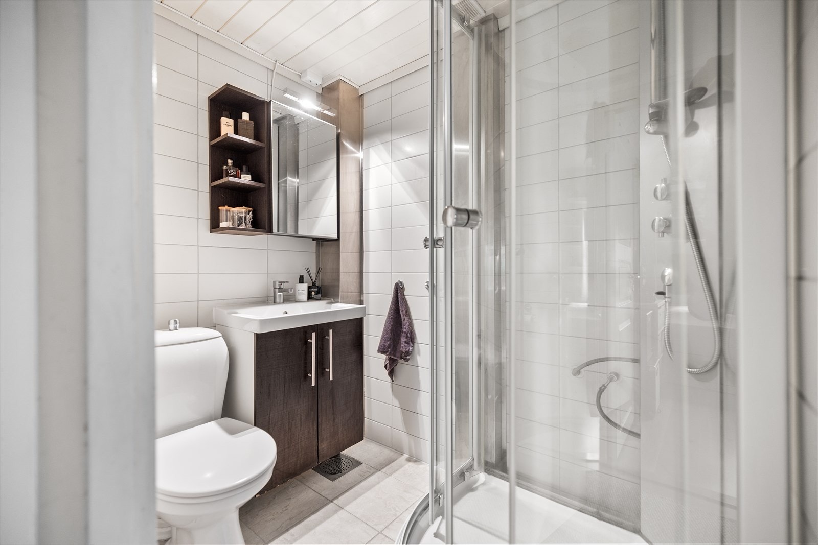 Badet er lyst og innbydende, med flislagt gulv og varmekabler som gir en behagelig varme under føttene året rundt. Galleribilde