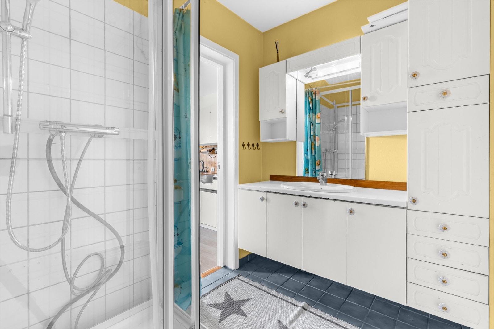 Badet har praktisk innredning med dusjkabinett og varmekabler i gulv. Galleribilde