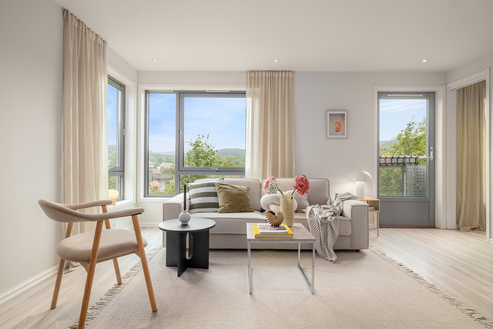 Lys stue med store vindusflater og fransk balkong. Tak og vegger er nymalt i en lys beigetone i 2025. Galleribilde